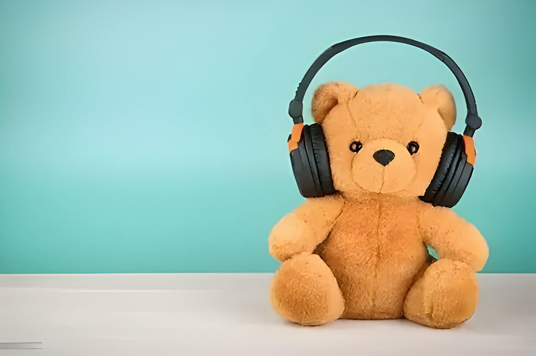 a brown teddy bear with black headphones on its ears