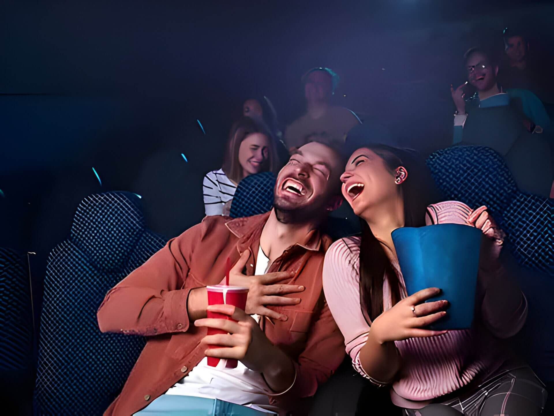 A young couple laughing at the cinema
