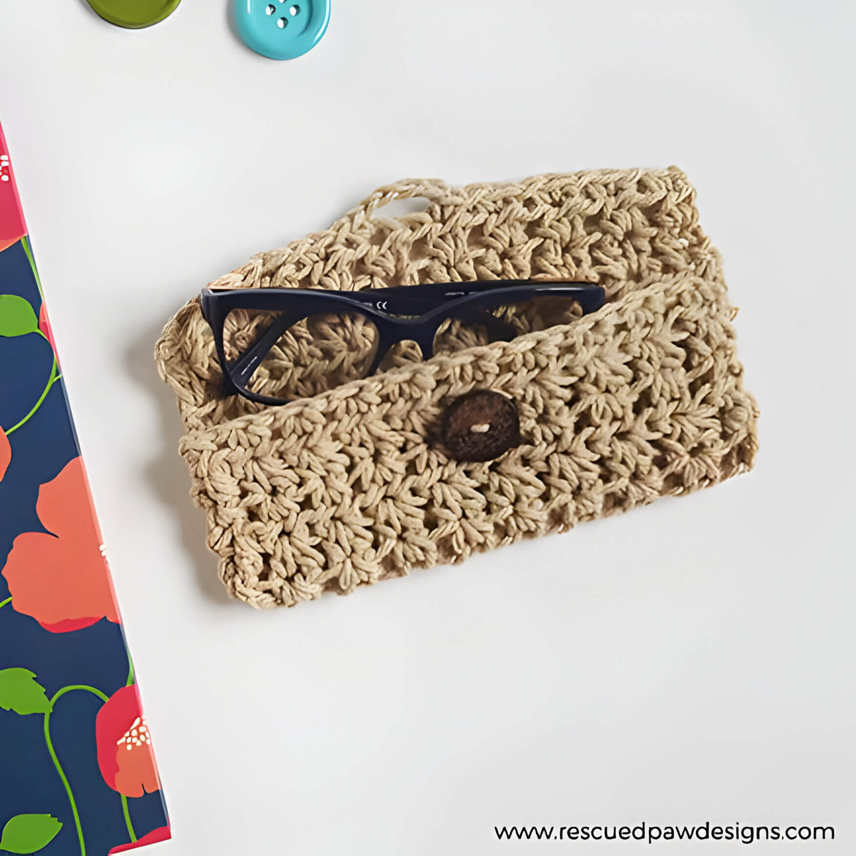a brown crochet glasses case with a pair of black glasses inside