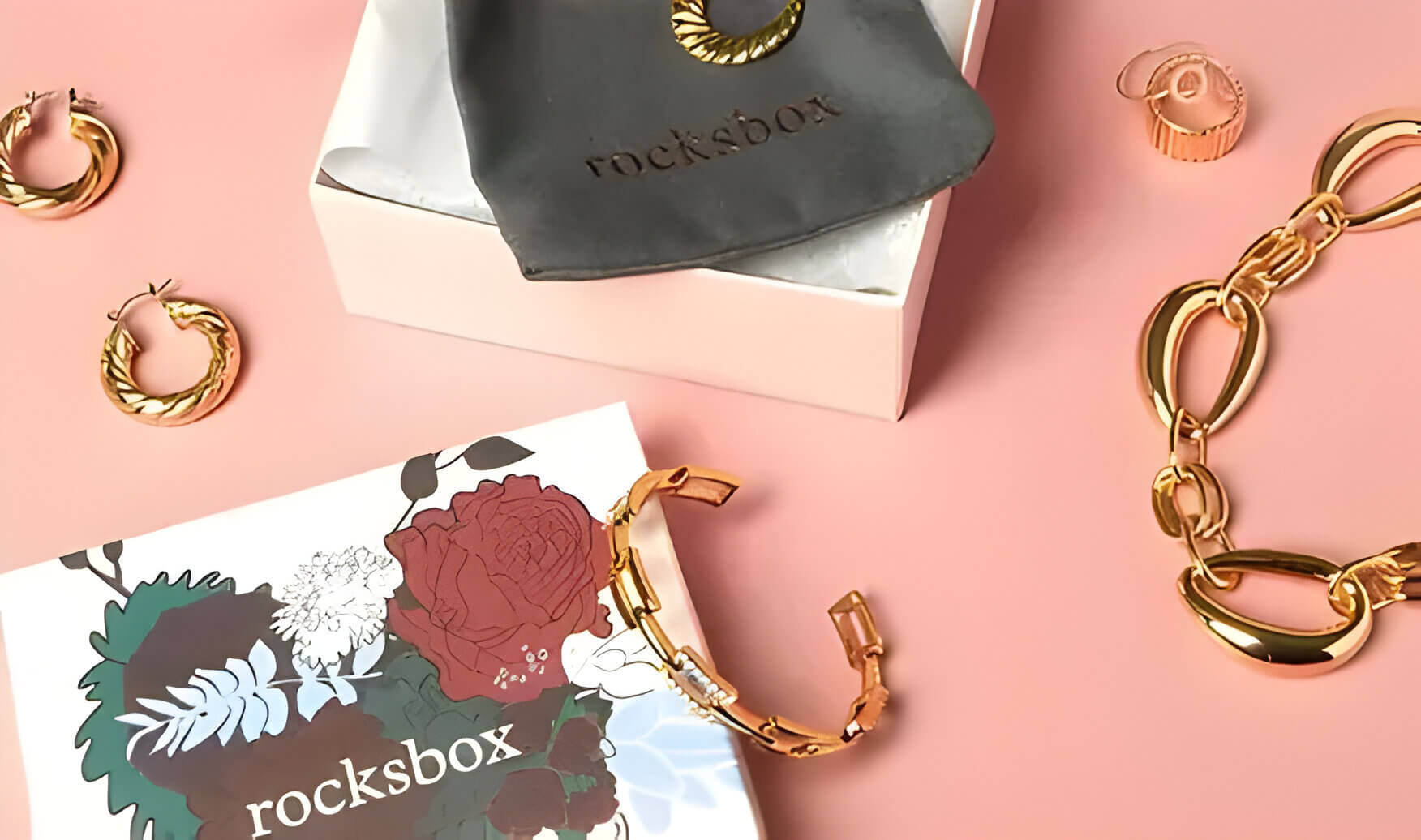 golden jewellery out of a monthly subscription box with a green bag and a box decorated in a floral design