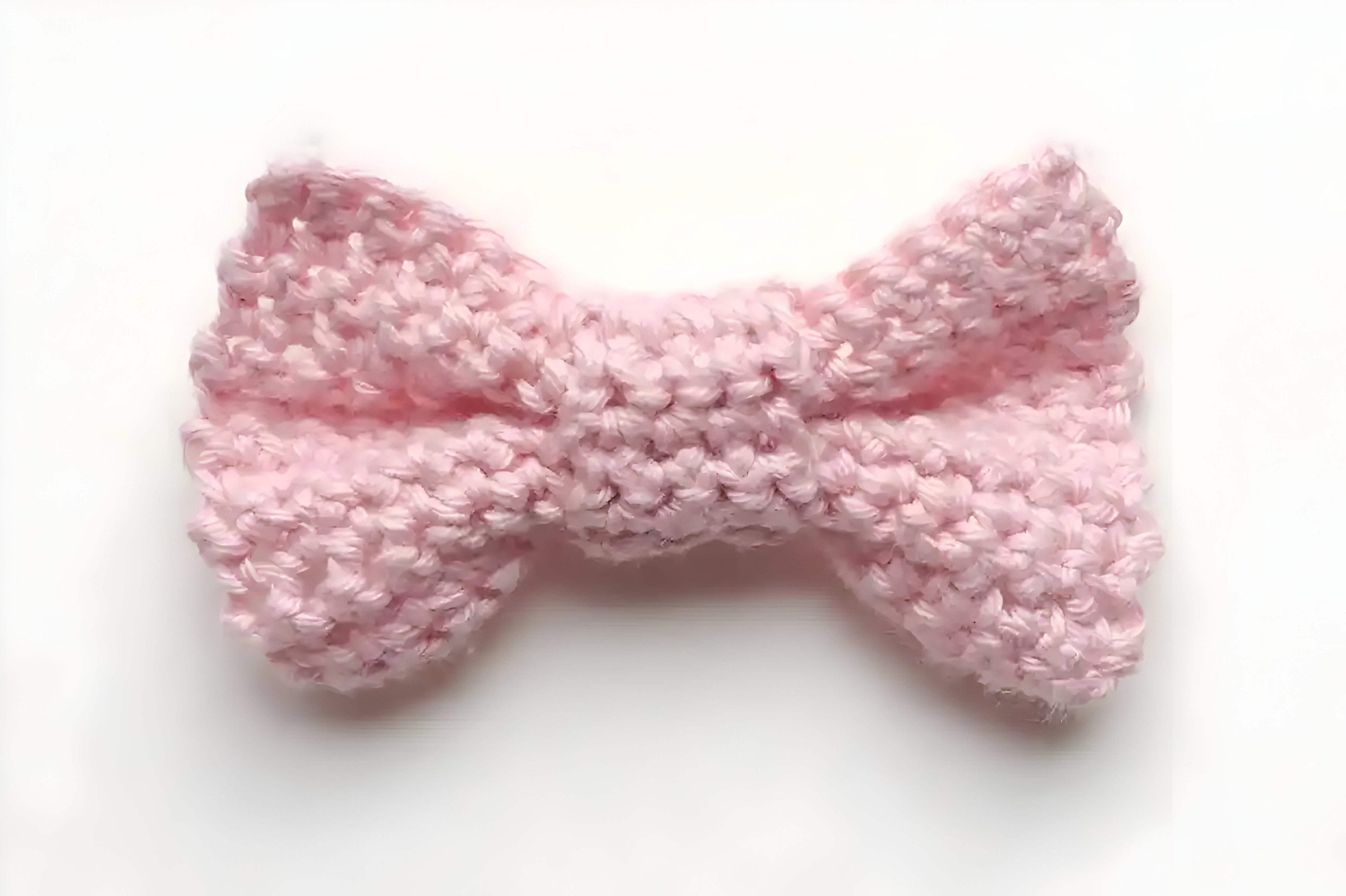 A pink crocheted handmade bow tie