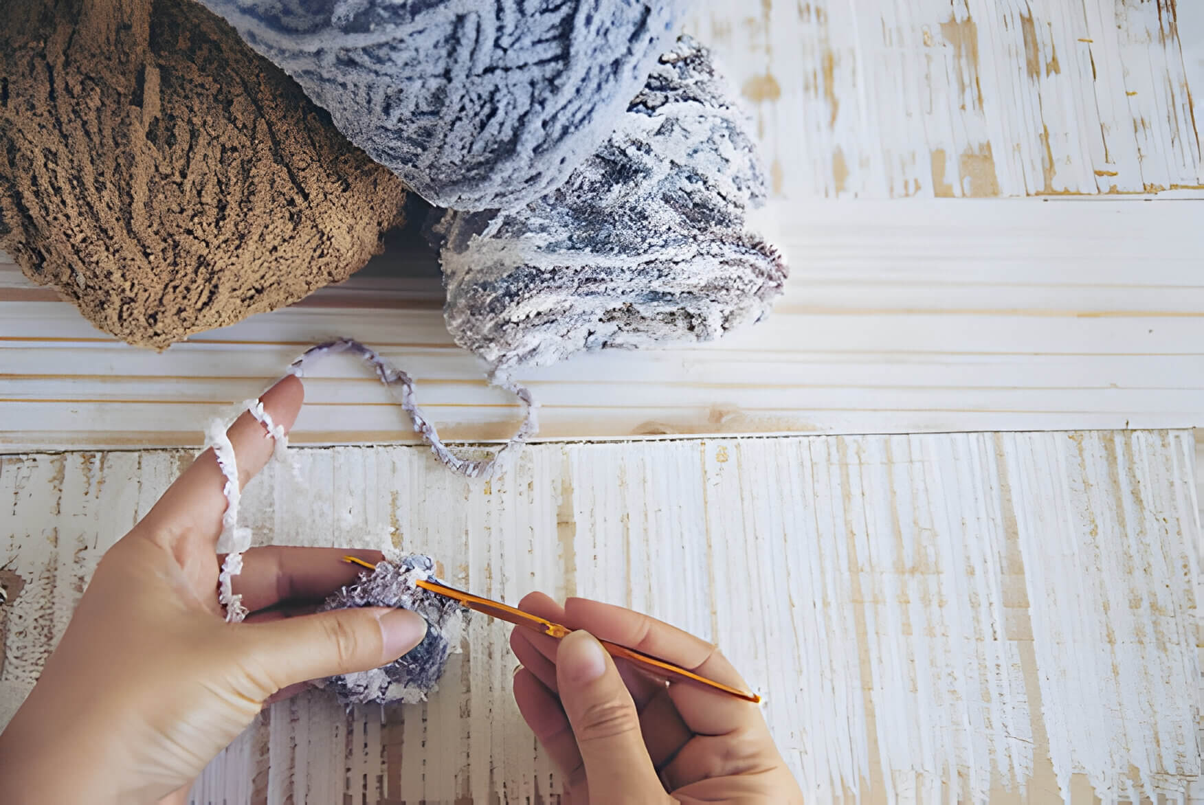 someone crocheting with blue and brown yarn