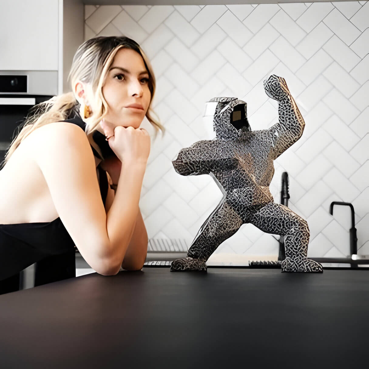 A lady leaning on a counter next to a magma giant bear figurine