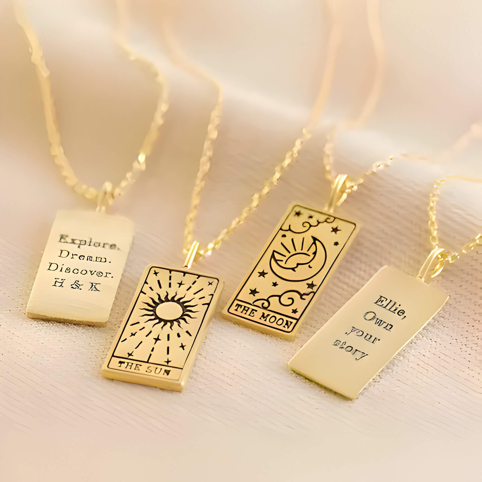 4 gold necklaces with tarot card pendants.