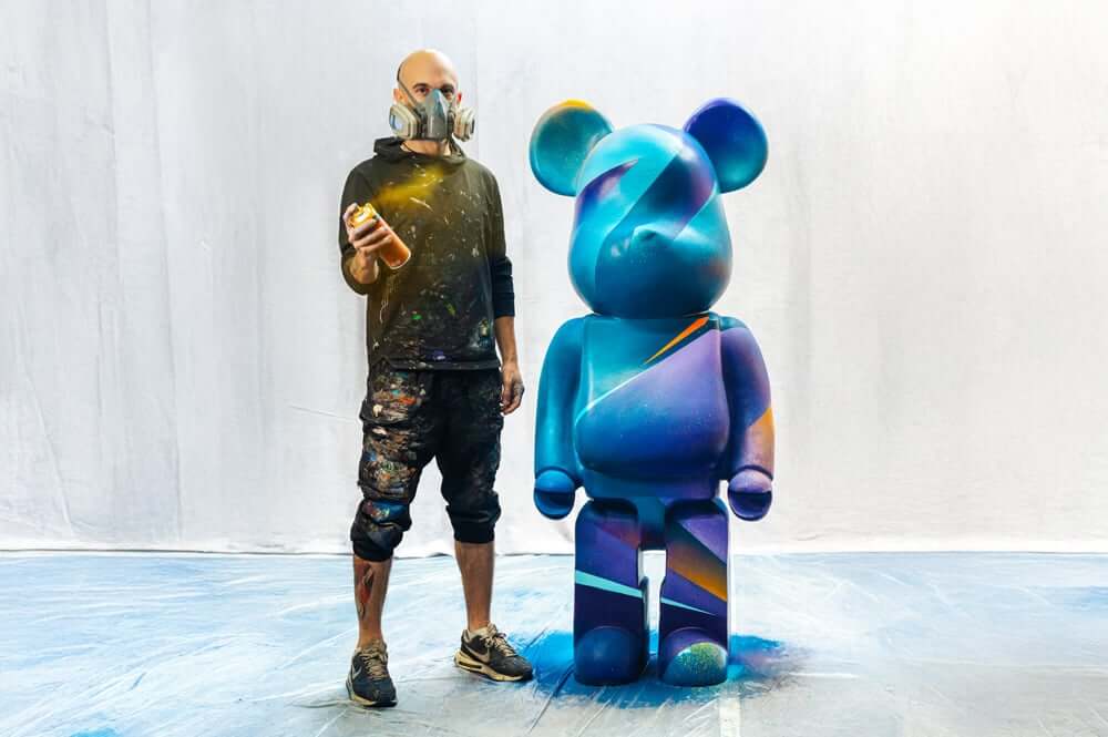 Midnight Sunset Bear Sculpture trailer, standing beside the artist Adam Illes.