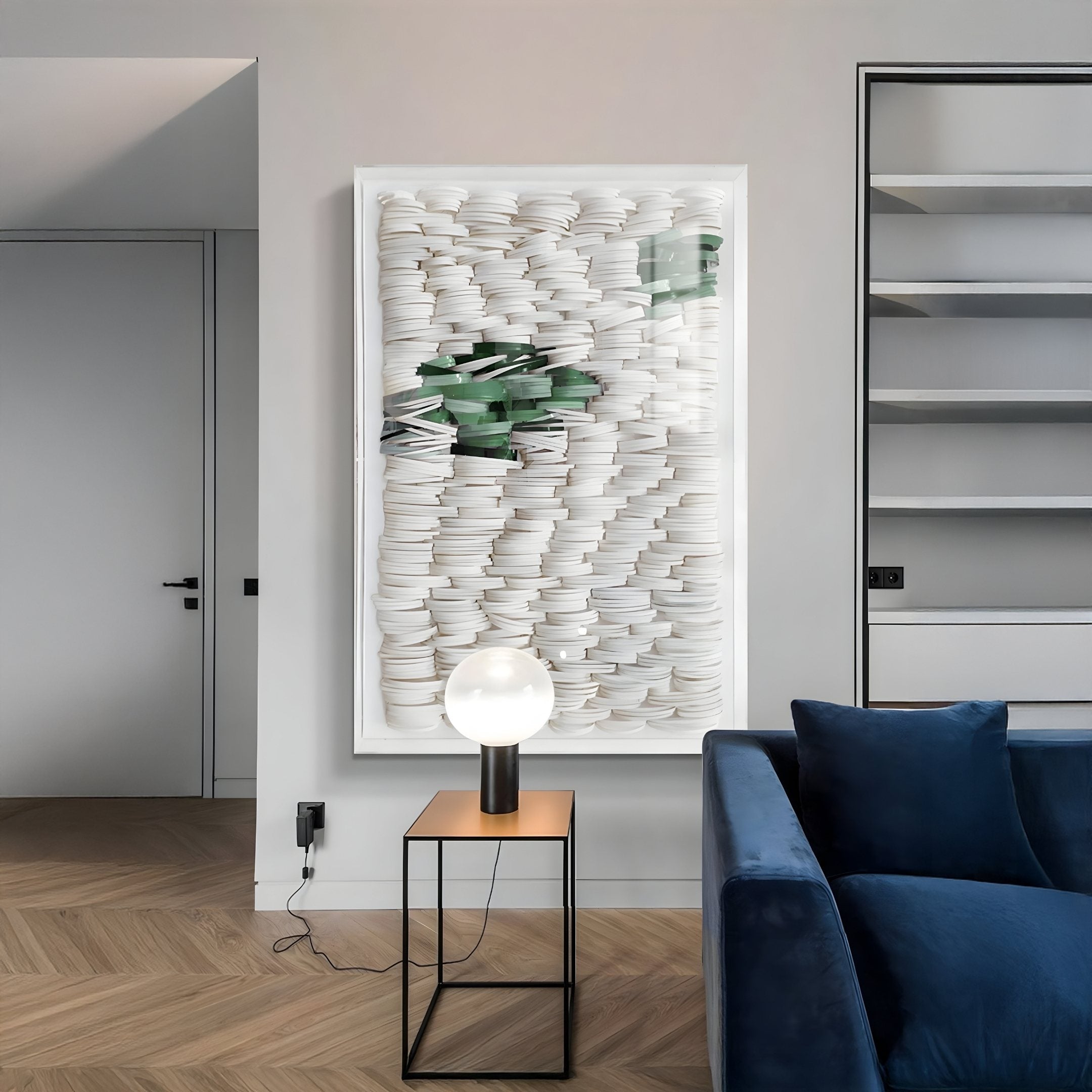 A modern living room with a vertical White & Green Acrylic Box 3D Paper Wall Art featuring layered white circular paper elements and a streak of green accents, adding sculptural texture and depth to a minimalist interior.
