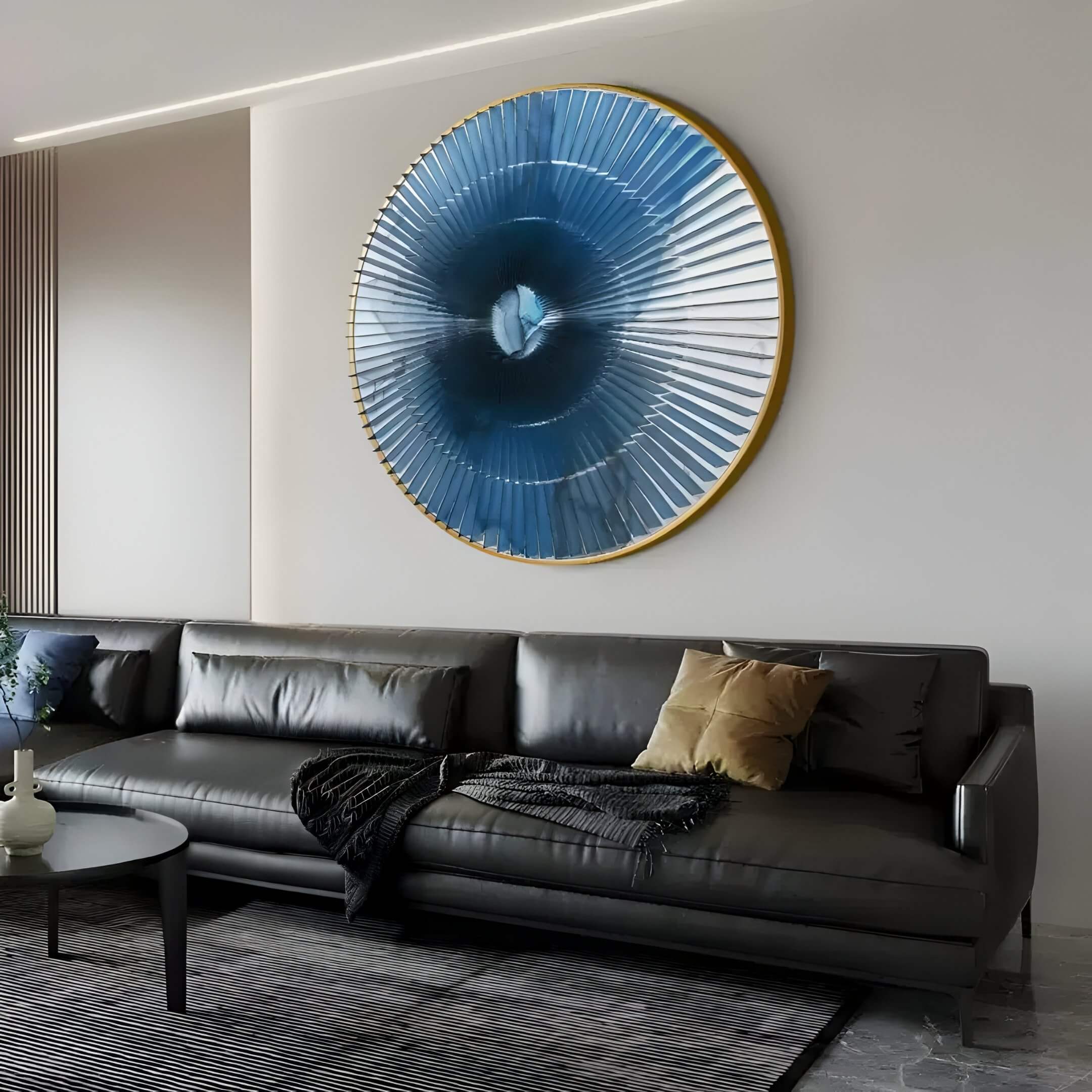 Large circular blue radial ripple acrylic 3D wall art with gold rim, mounted above a modern black leather sofa in a contemporary living room.