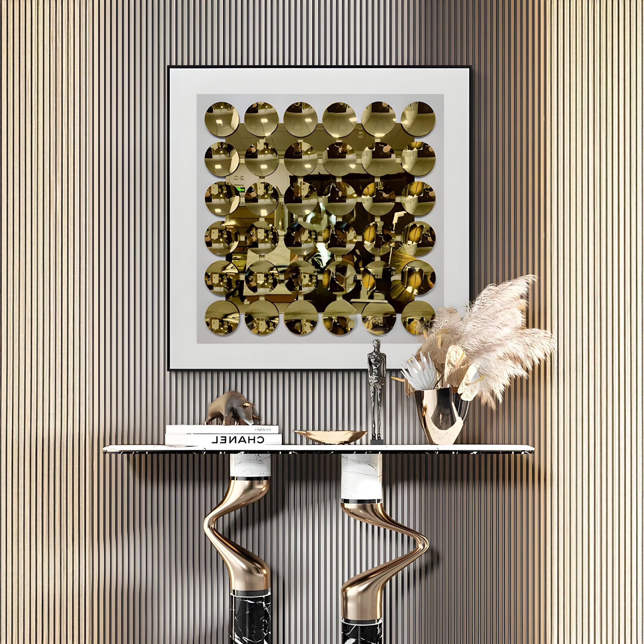 Luxury interior with framed gold mirror disc acrylic 3D wall art above a modern marble console table, styled with pampas grass in metallic vase.