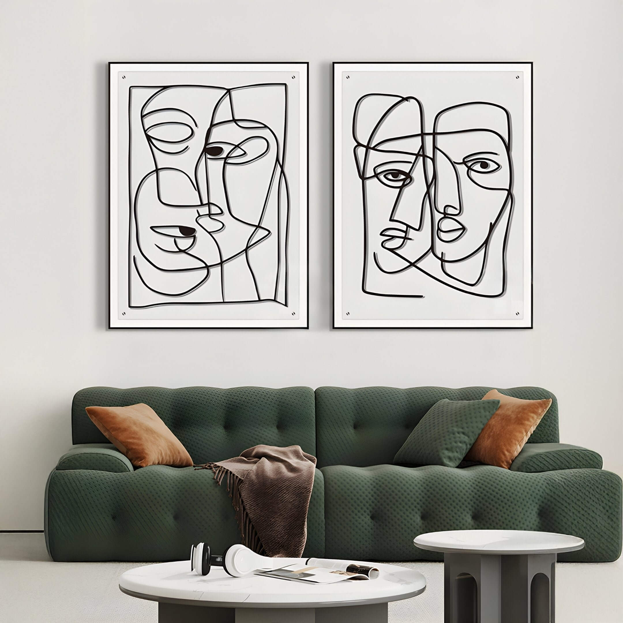 Minimalist black line face drawings in a modern living room with a green sofa.