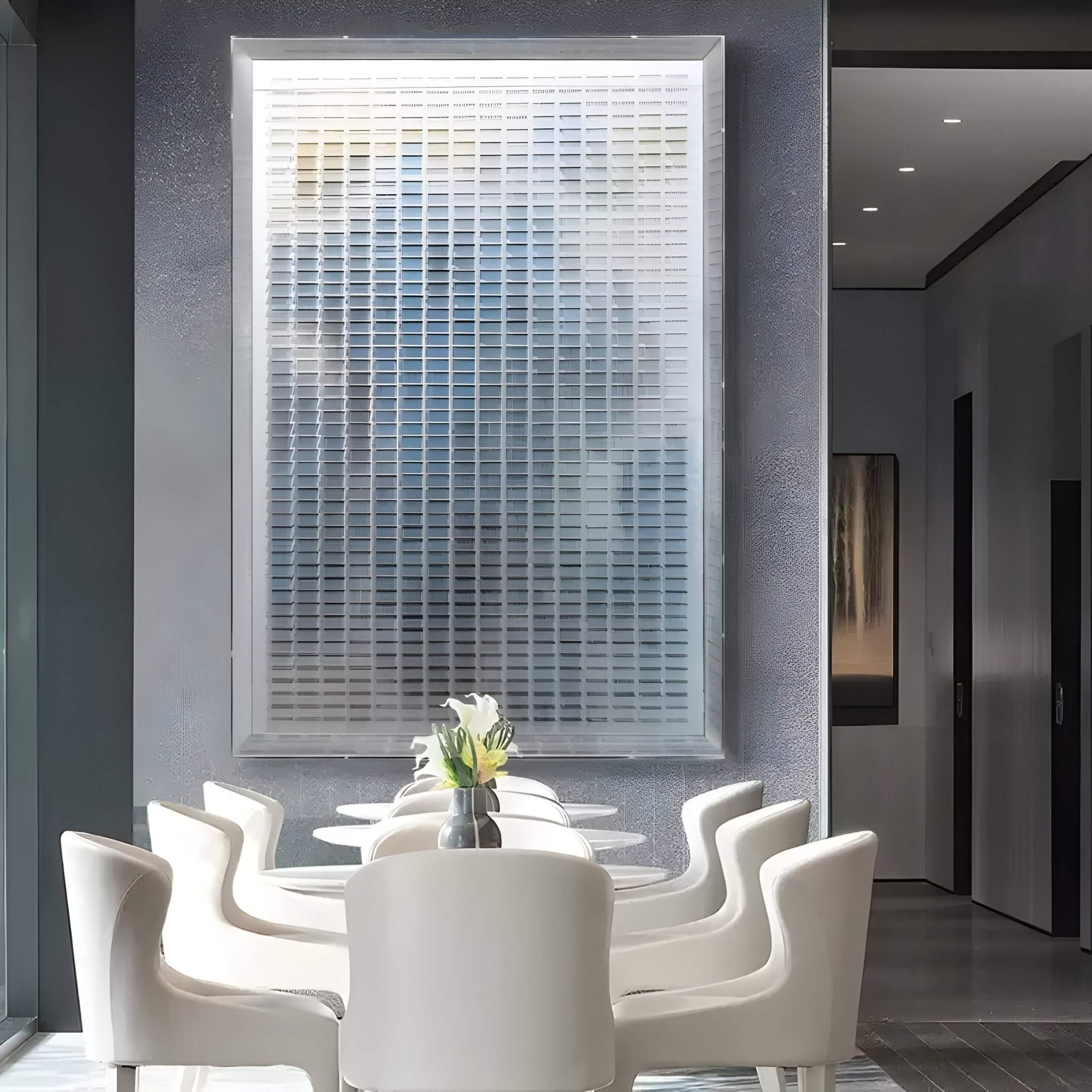 A bright, minimalist dining area with white chairs around a sleek table, a small flower vase, and the Chromat Nebula Blue Gradient Acrylic 3D Wall Art by Giant Sculptures adding contemporary style to the wall behind.