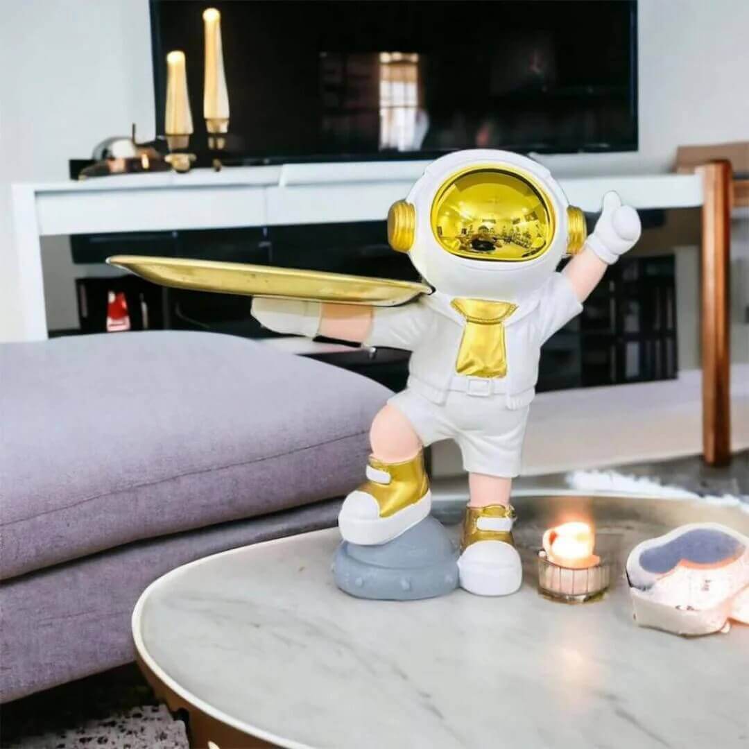 Decorative astronaut figurine with a golden tray and helmet, placed on a marble coffee table in a modern living room.