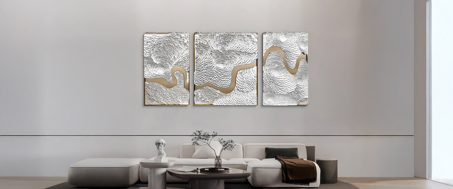 Abstract Art: A modern living room featuring a three-panel silver and gold abstract wall art piece, mounted above a minimalist white sofa with sleek decor elements.