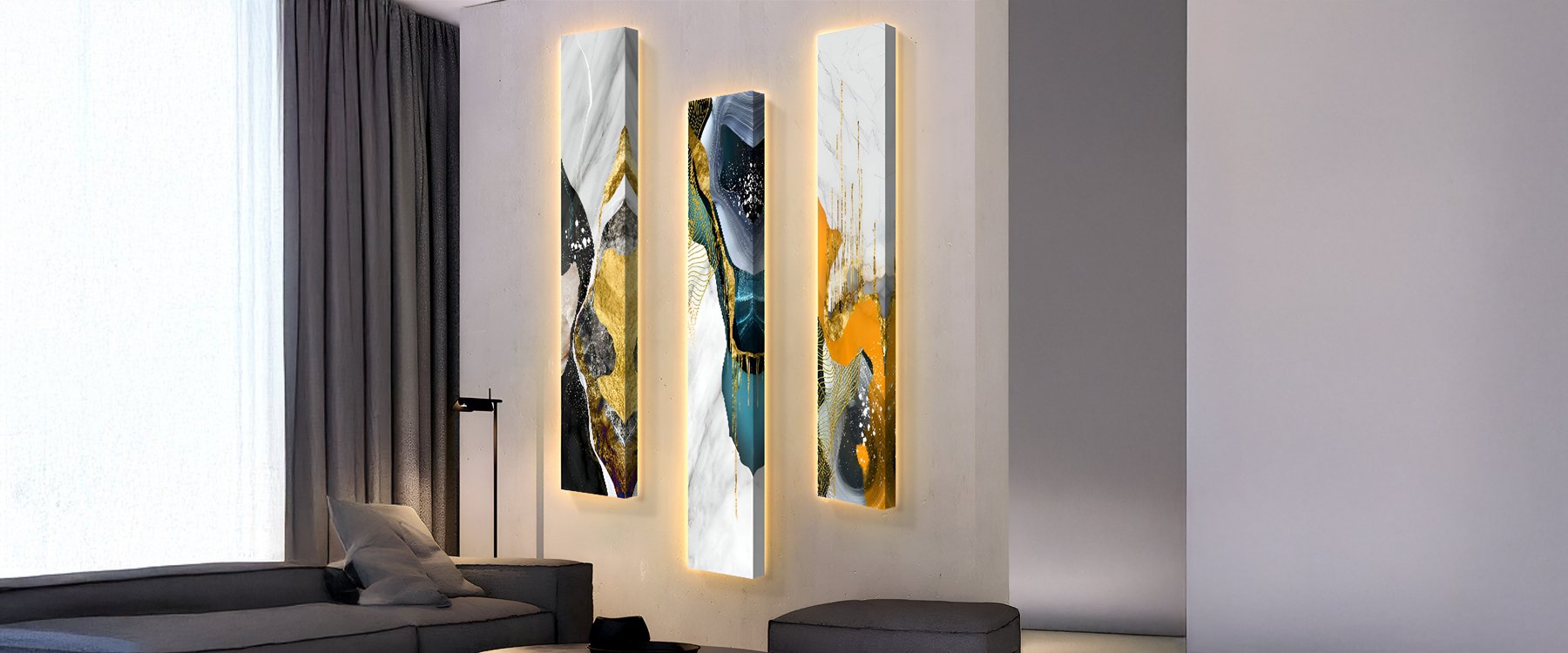 Set of three vertical abstract wall art panels with gold, blue, and white accents, enhanced by soft backlighting, displayed in a modern living room with minimalist decor.