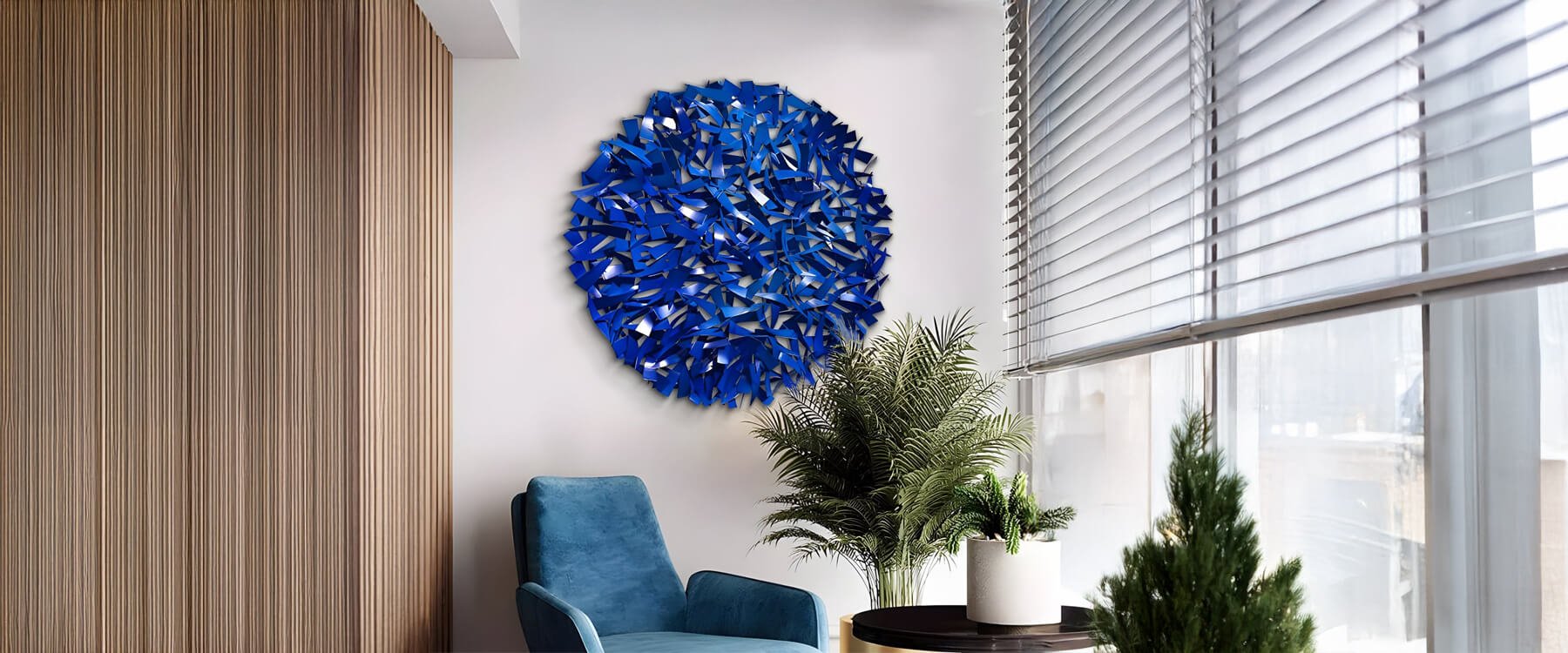 Contemporary blue metal 3D wall art with intricate overlapping elements, featured in a cozy corner with a blue chair, wooden paneling, and indoor greenery.