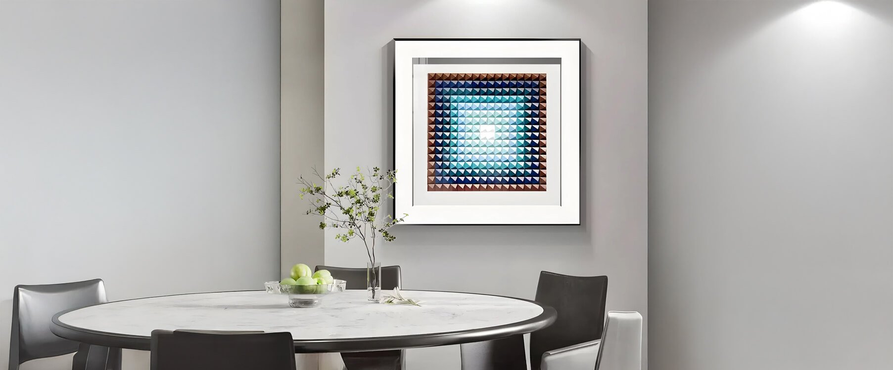 Framed geometric blue dining room art above table – A modern dining space featuring a square framed blue geometric artwork mounted on a neutral wall.