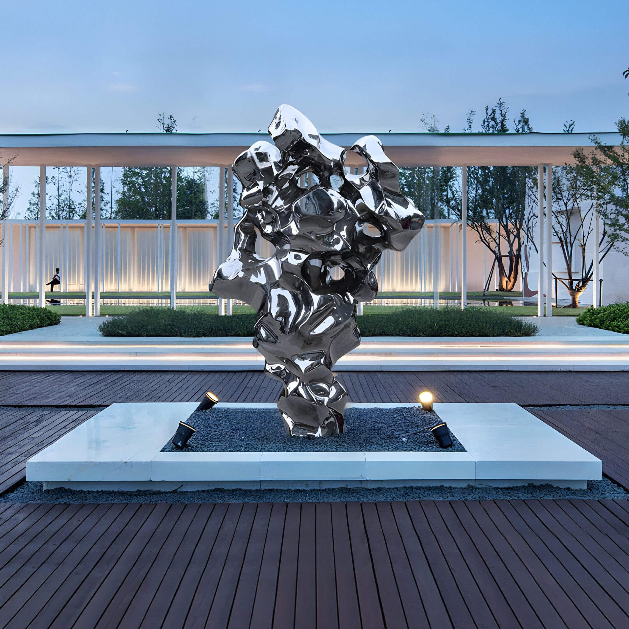 Abstract metallic outdoor sculpture with spotlight base