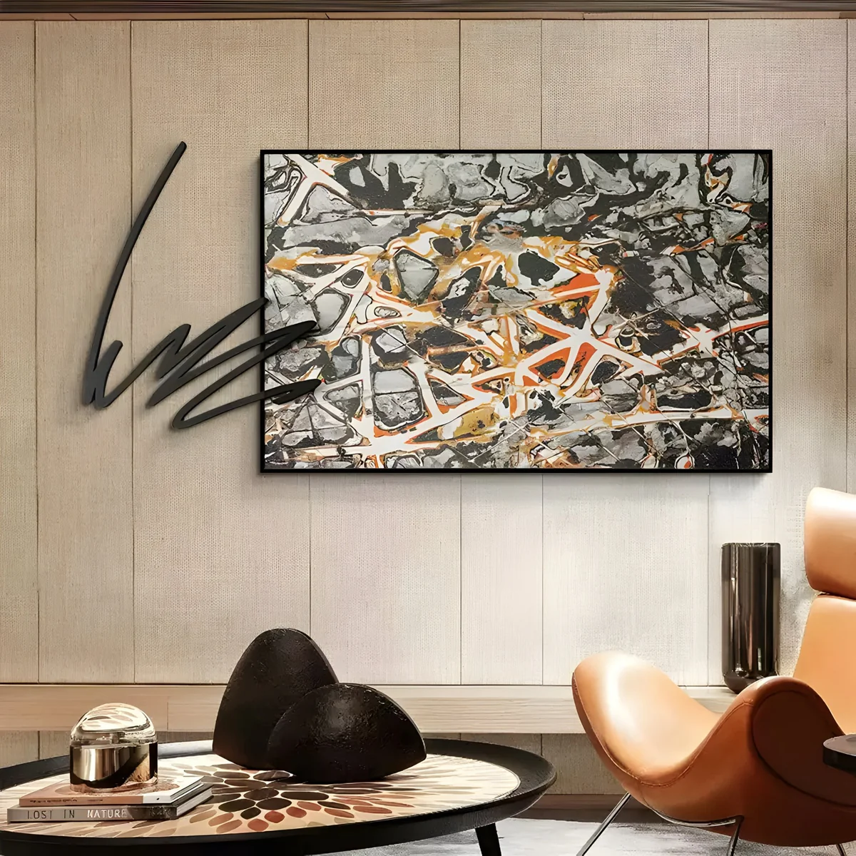 A modern luxury interior showcasing canvas art with an intricate mix of black, grey, orange, and white hues, complemented by a designer leather chair and textured decor.