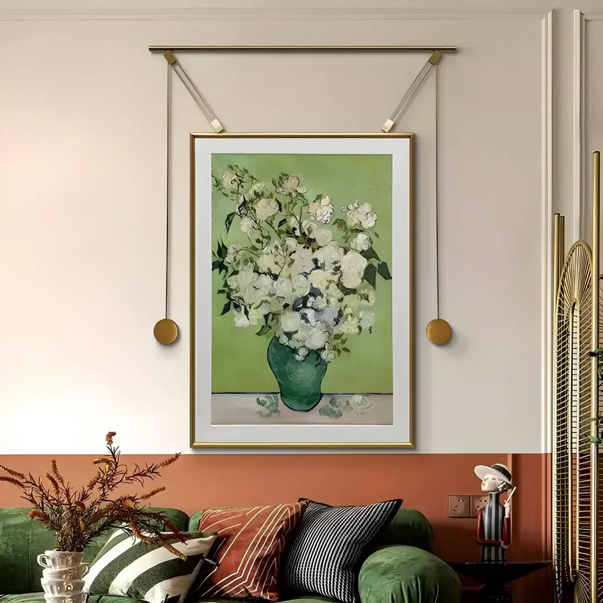 A charming living space featuring a framed floral artwork with a green background, elegantly hung with gold accents above a stylish green sofa.