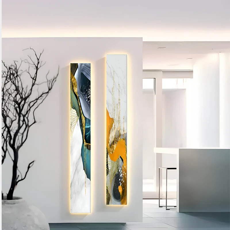 A modern hallway adorned with two vertical abstract paintings featuring gold, blue, and white textures, illuminated for a striking effect.