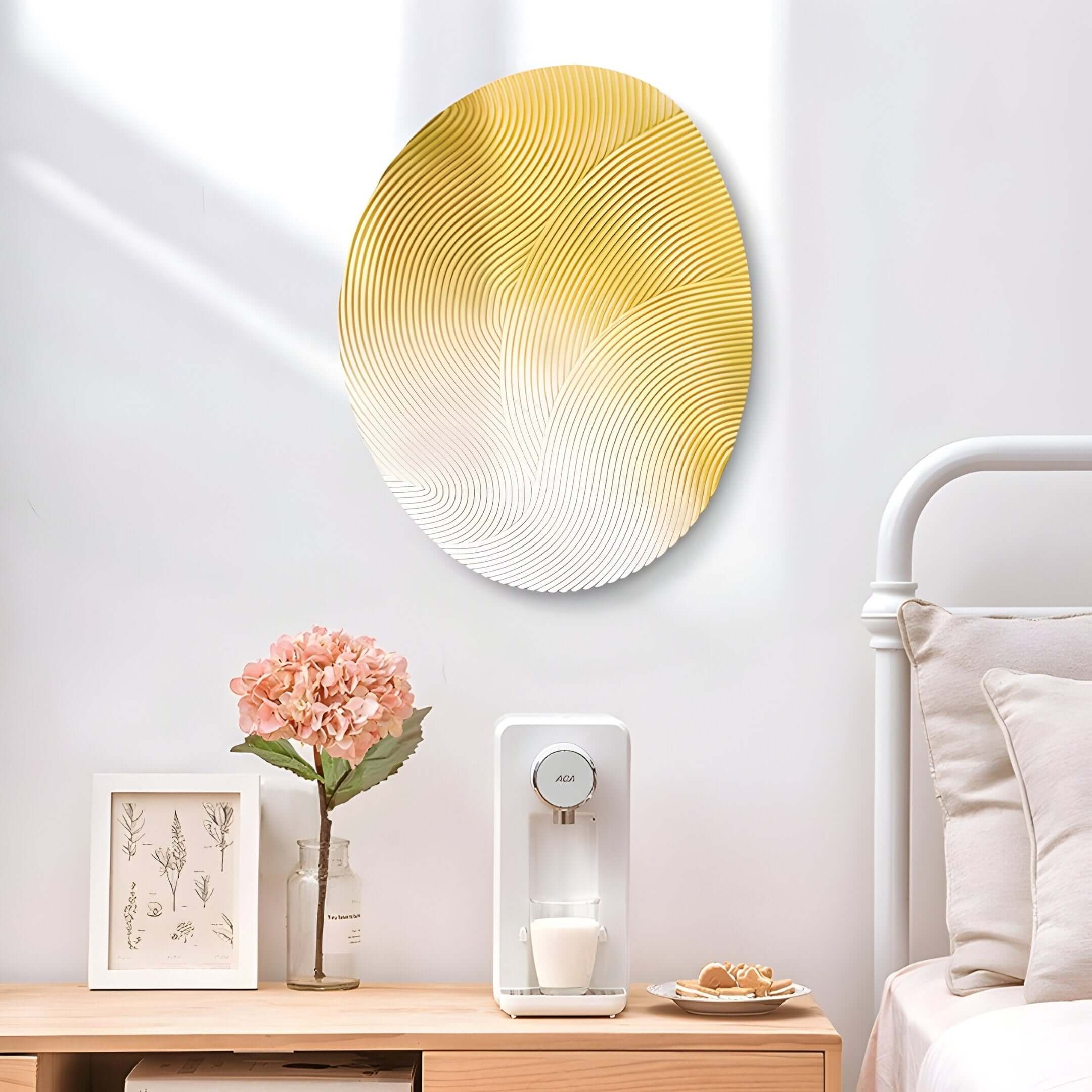 In a serene bedroom corner hangs the Fluctus Yellow Textured Sandstone Wood Relief 3D Wall Art by Giant Sculptures, next to a framed botanical print. A small white appliance on the wooden nightstand is complemented by pink hydrangeas and hand-carved grooves in the headboard, adding depth to the tranquil setting.