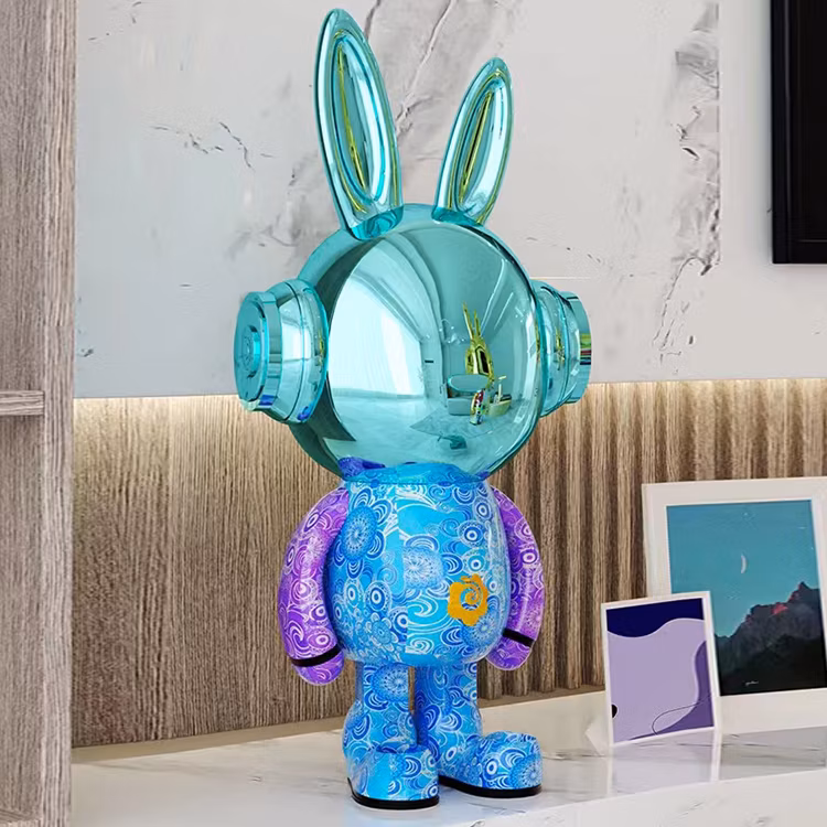 A colorful resin bear sculpture with neon streaks sits on a white display stand in a modern living room.