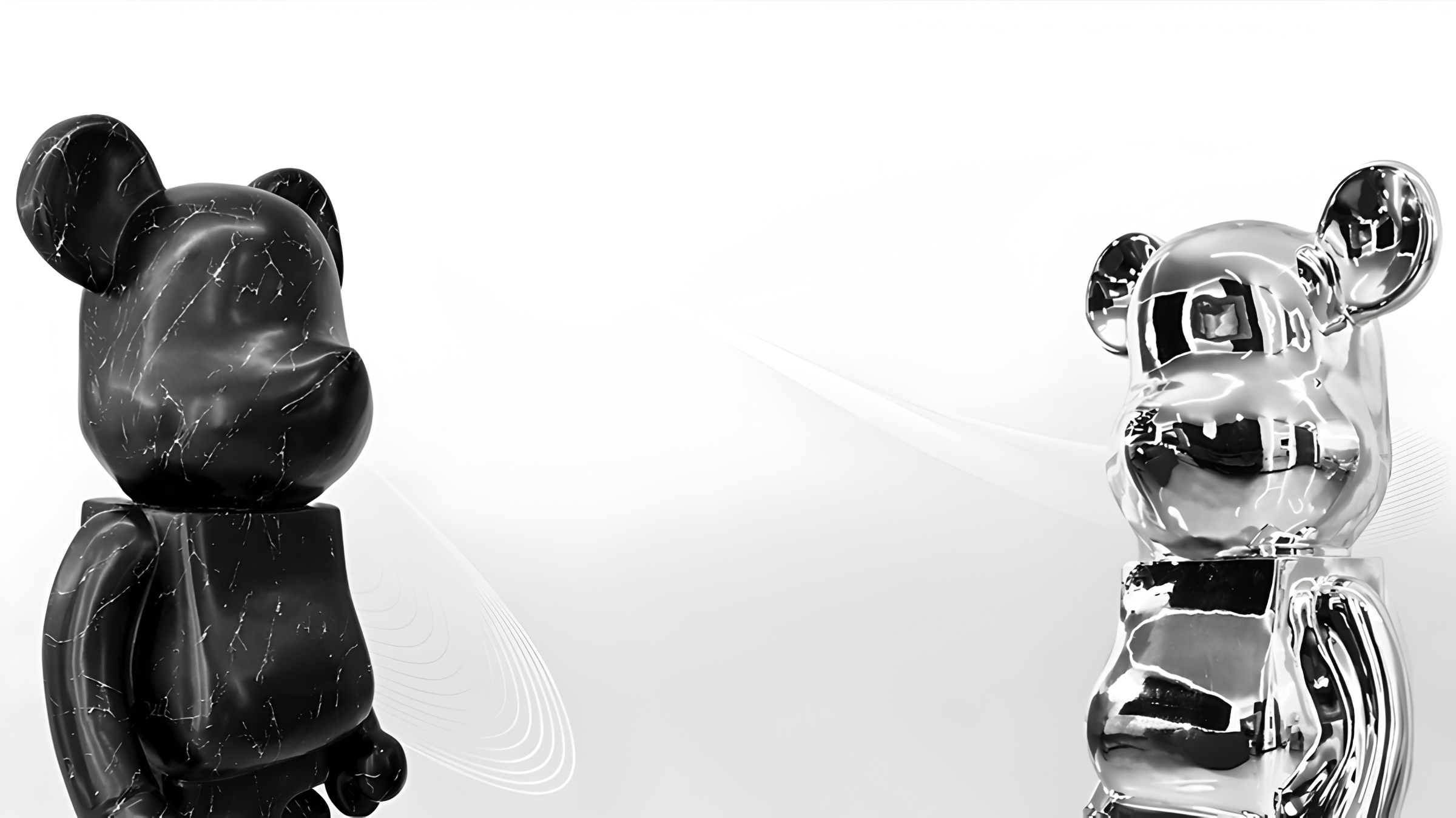 Contrasting animal sculptures featuring a black bear with white marble veins and a reflective silver bear, showcasing modern artistic appeal against a minimalist white background.