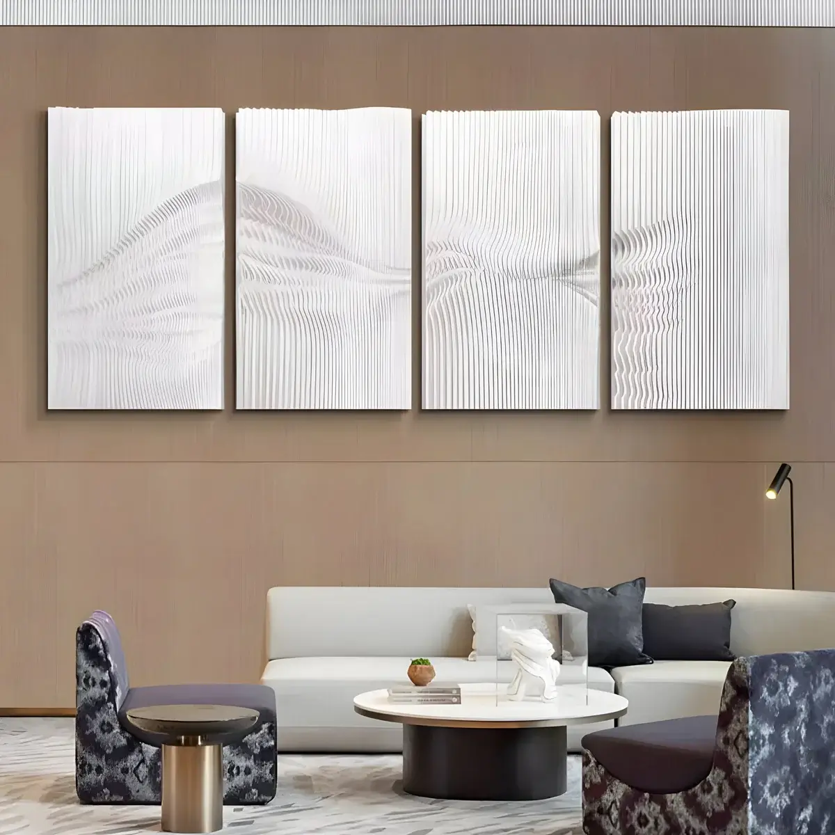 A textured, sculptural wall art piece in white with dynamic patterns, displayed above a modern light-colored sofa with minimalistic décor and geometric furniture in a cozy living room.