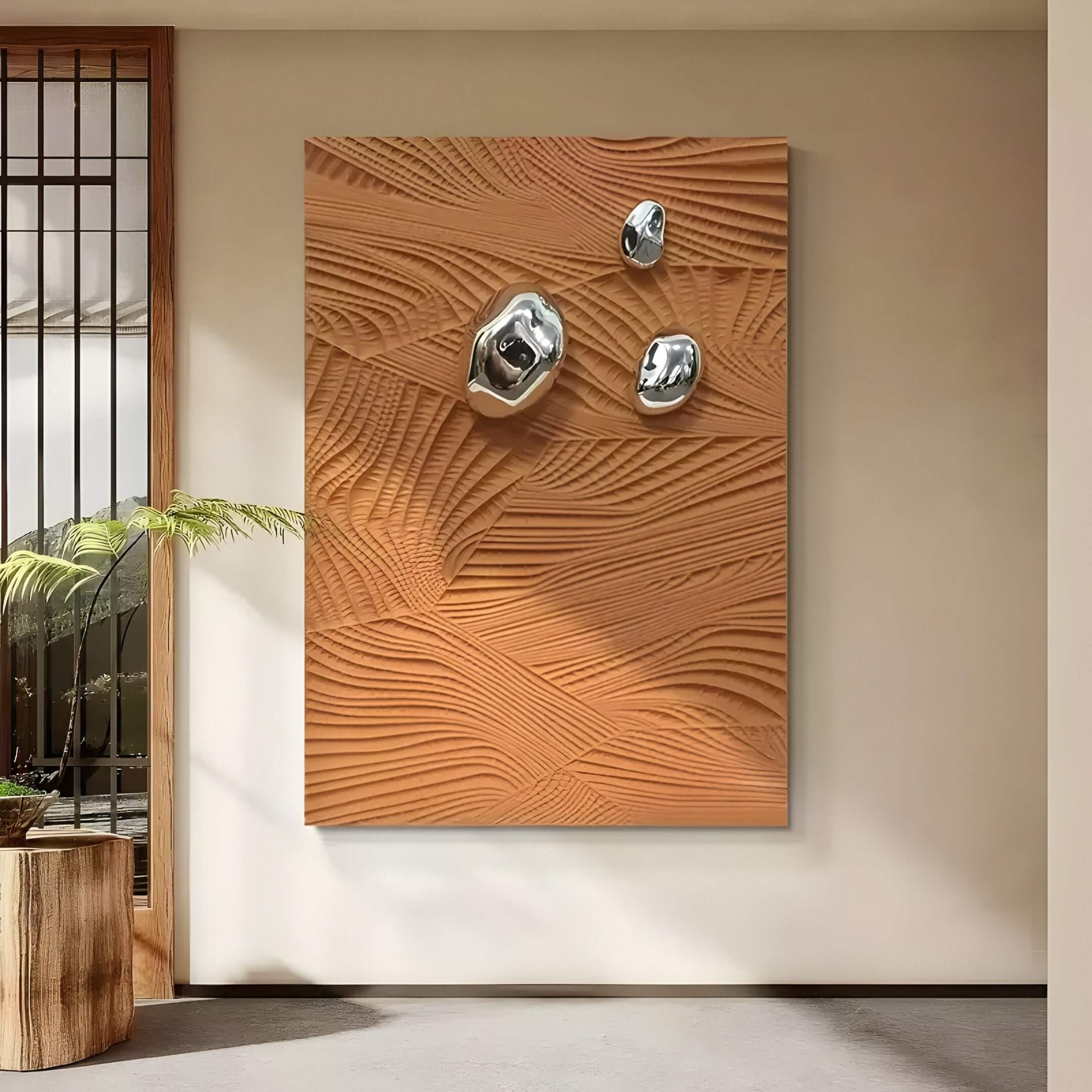 A modern interior showcases Verdara Terracotta Wood Relief 3D Wall Art by Giant Sculptures, alongside abstract silver sculptures. A small potted plant on a wooden stand sits nearby, as natural light filters through a window with wooden slats.