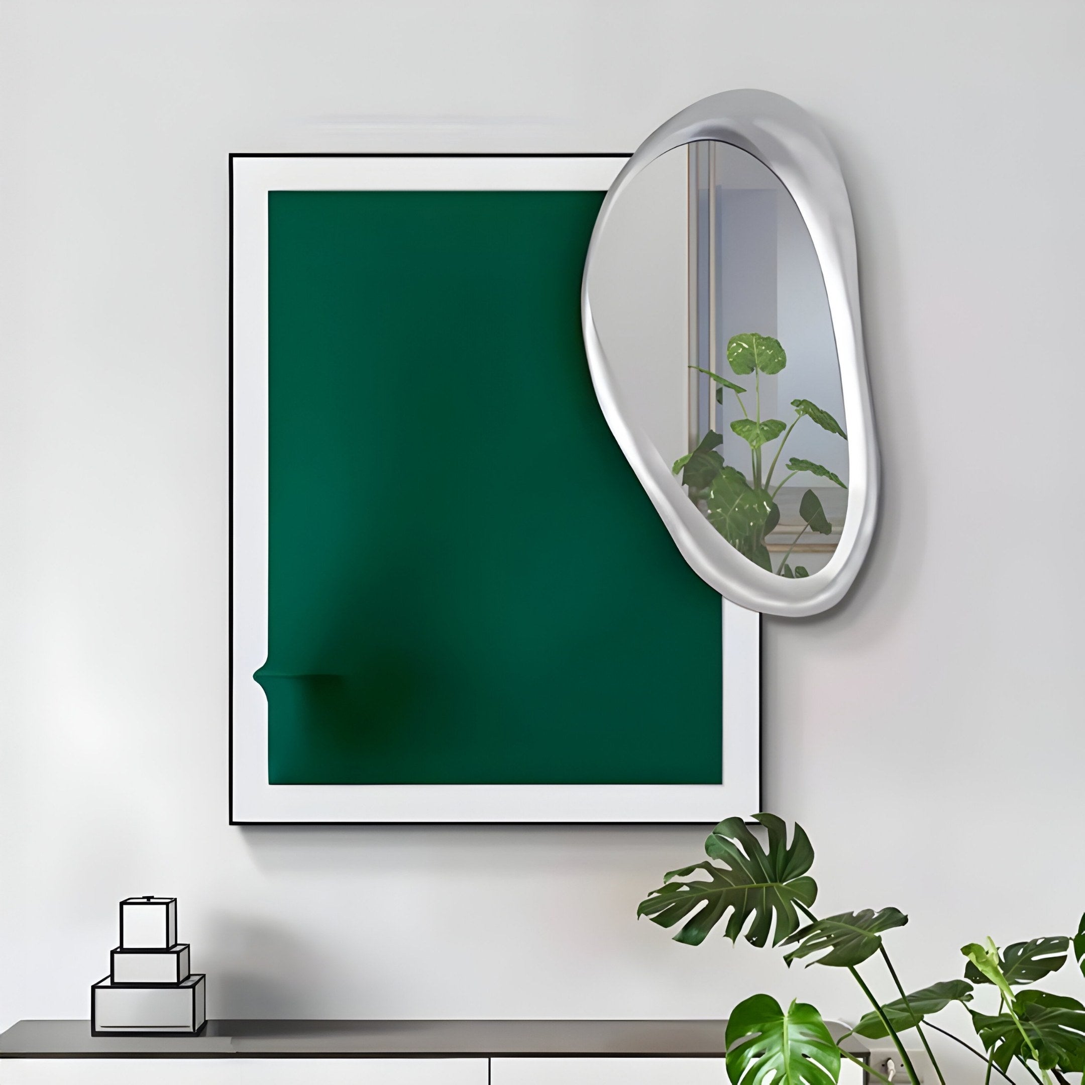 A modern art display features the Reflectra Green Wood Relief 3D Wall Art With Silver Mirror by Giant Sculptures, showing a green canvas and a melting look. Near it, an irregular silver mirror reflects a plant. Below, there’s a table with a small geometric sculpture and a potted plant with large leaves.