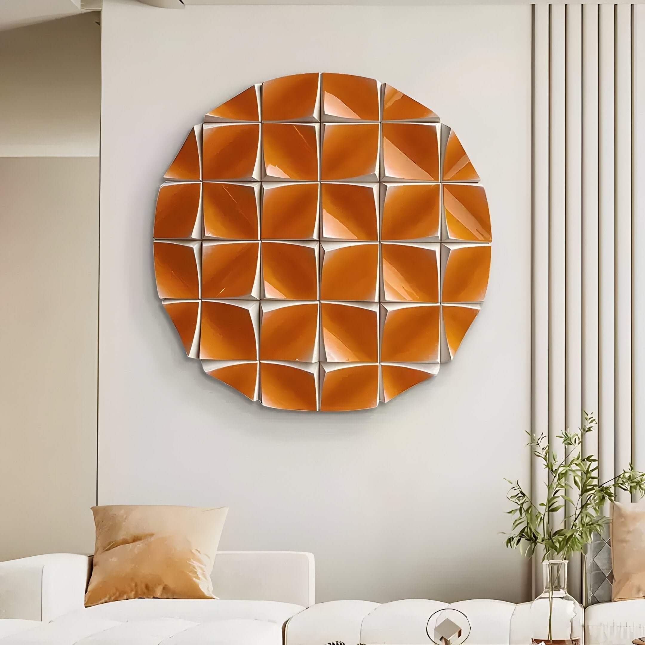 The Incalia Orange Circular Geometric Wood Relief 3D Wall Art by Giant Sculptures hangs above a modern white couch with beige pillows, adding prismatic dimension and vibrant style next to a small nearby plant.