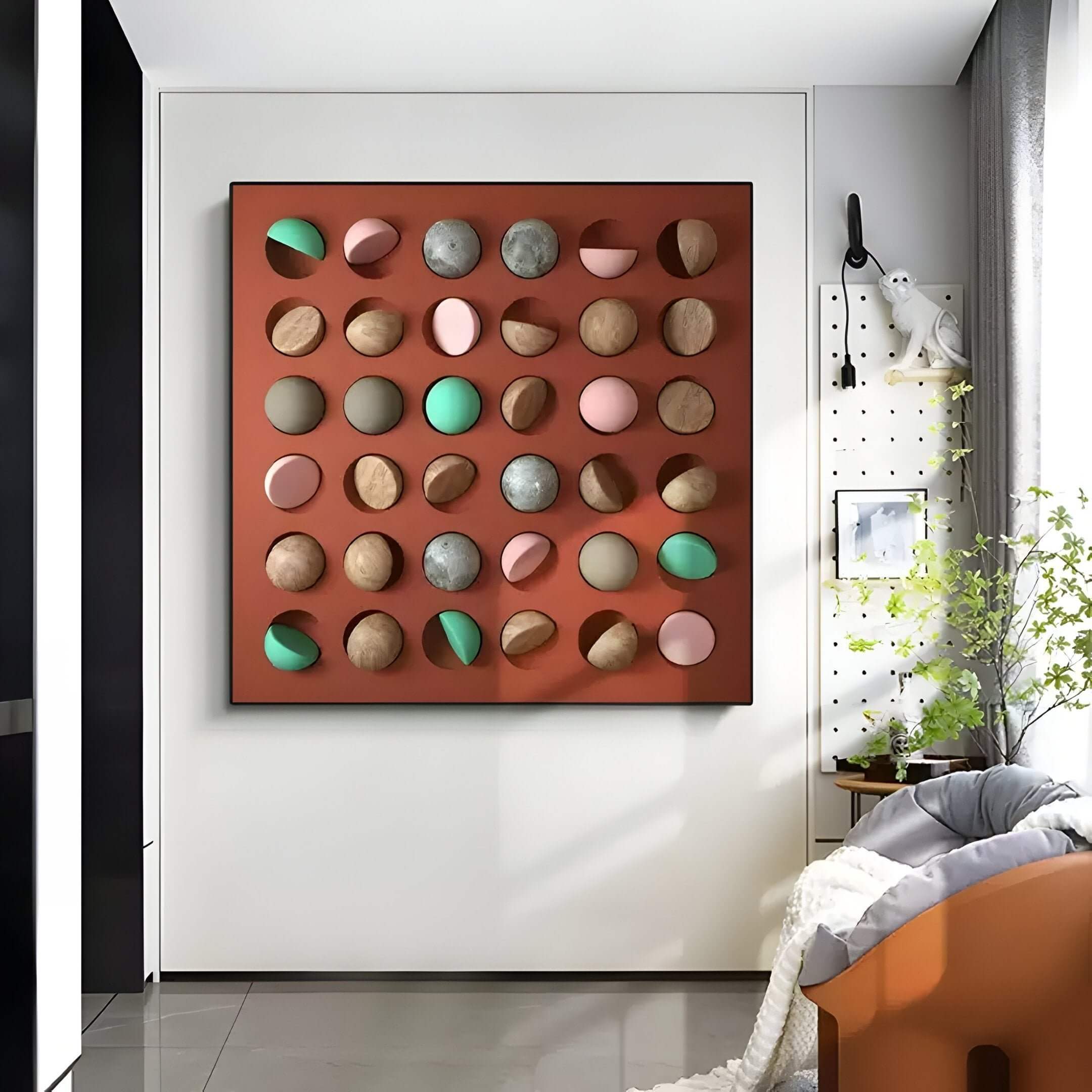 A modern interior features the Giant Sculptures Formexa Sphere Geometric Wood Relief 3D Wall Art, showcasing multicolored circular elements on a brown background. A cozy chair, small plant, and minimalist decor add style and an unexpected elegance.