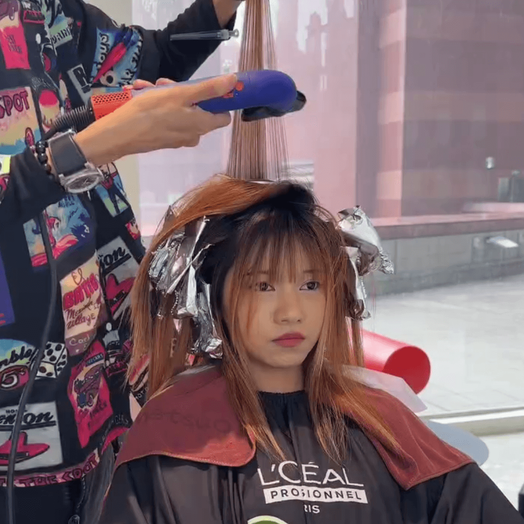 The Air Touch Balayage technique uses a blow dryer to gently separate weaker, shorter hairs, ensuring only the strongest strands are colored for a natural, blended look.