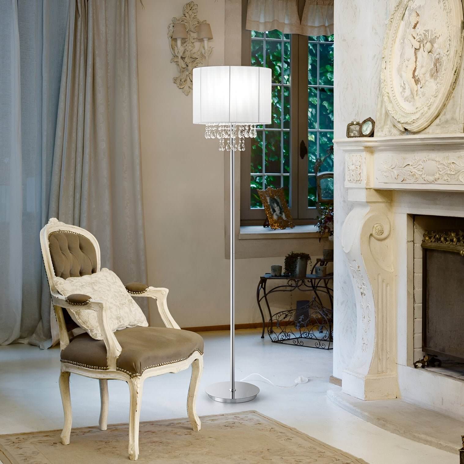 Chrome floor lamp with pleated drum shade and hanging crystals in a classic white sitting room with ornate detailing.