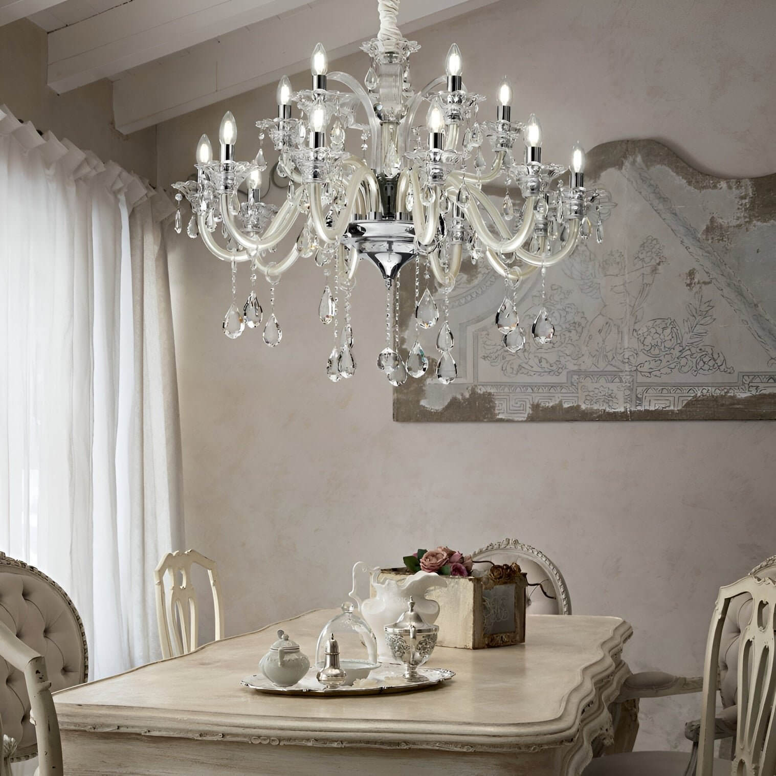 Crystal and ivory chandelier above a vintage dining table with ornate chairs and antique-style decor.