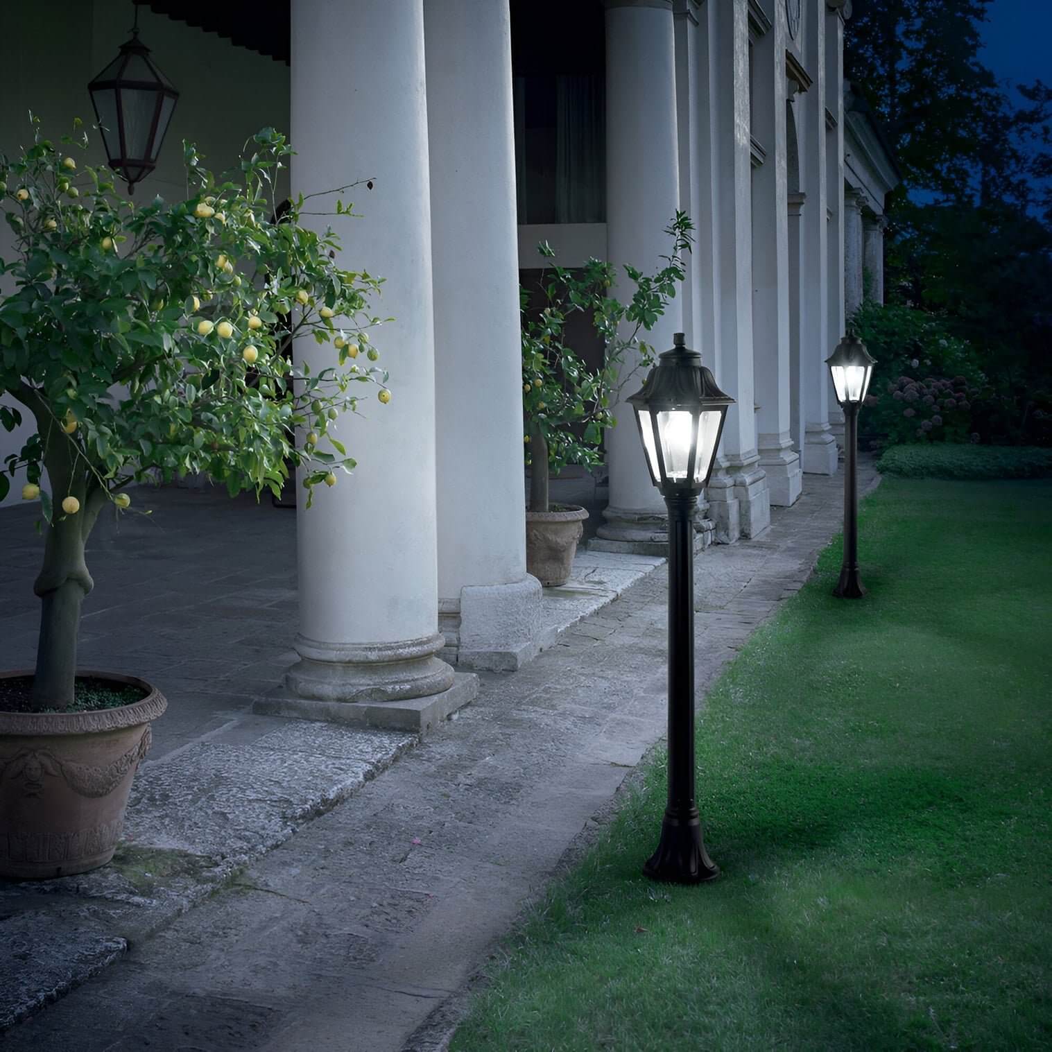 https://niori.co.uk/products/gaze-1-light-lamp-post-blackElegant garden scene with vintage lamp posts lighting a columned terrace and lemon trees.