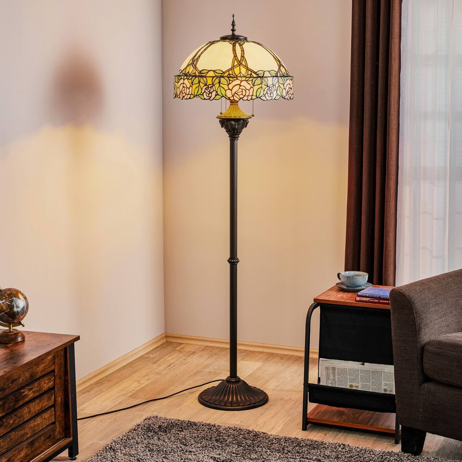 Tall floor lamp with dome-shaped Tiffany glass shade and bronze base in a cozy corner next to an armchair