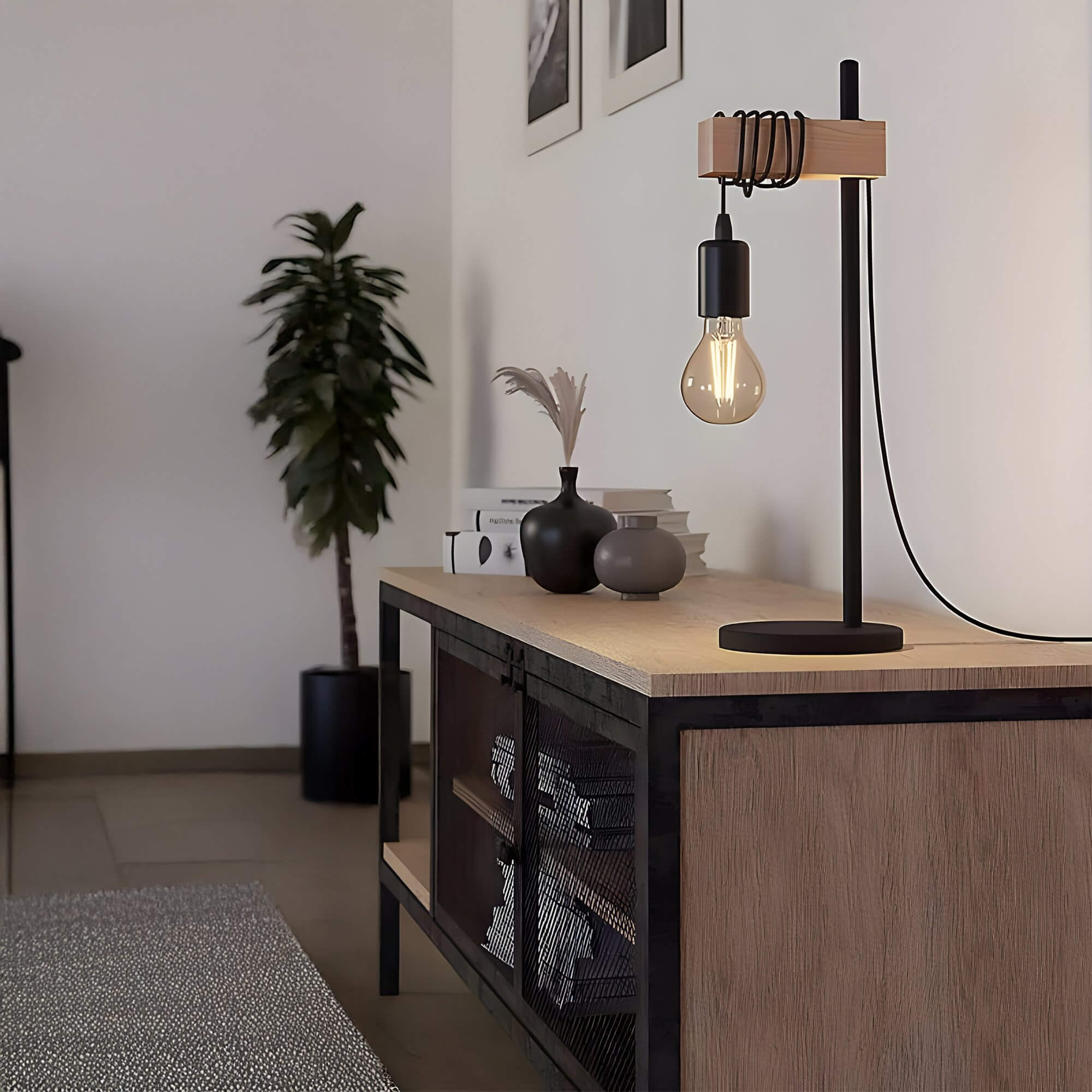 Minimalist table lamp with exposed bulb and wood accent base on a sideboard in a neutral-toned hallway.