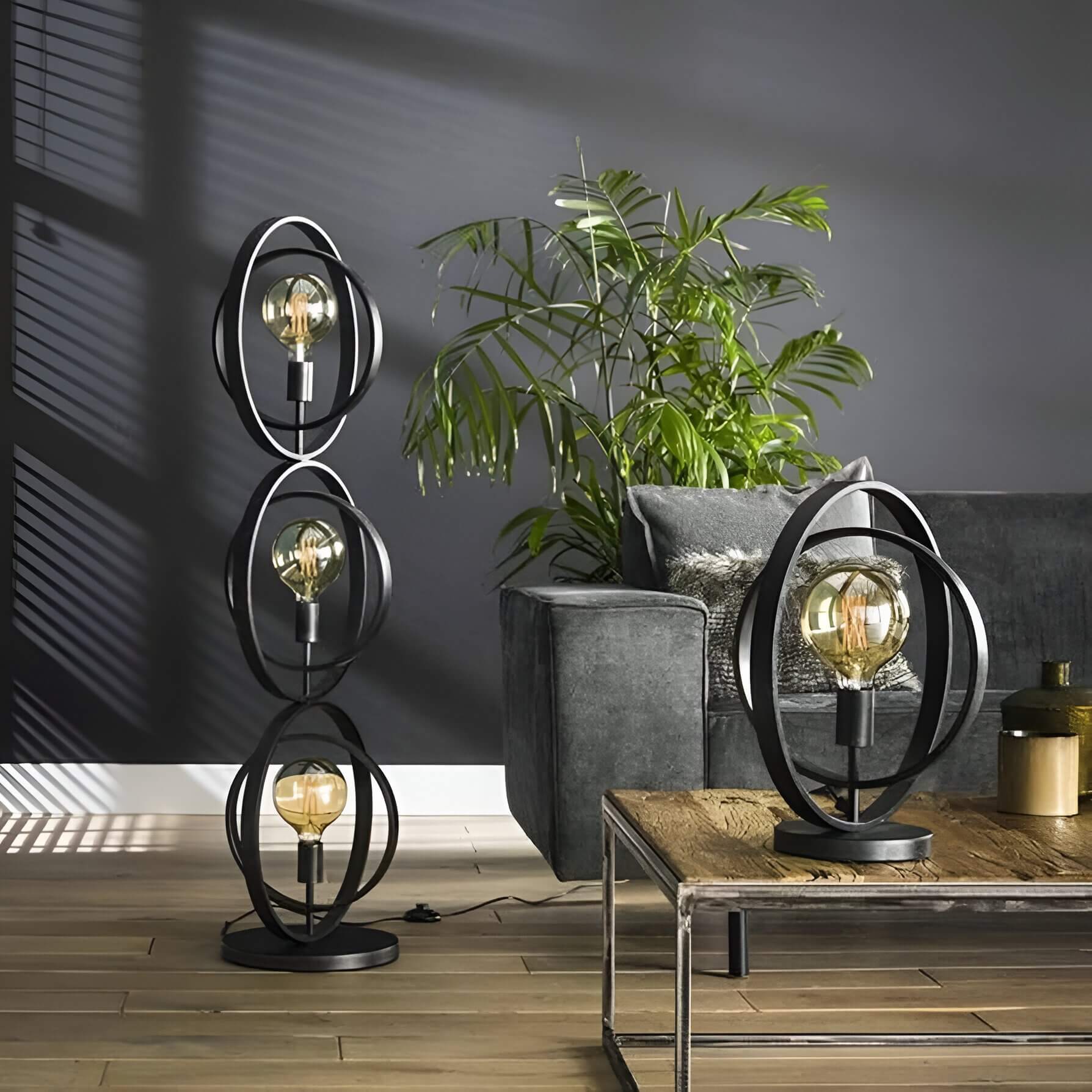 Black metal ring floor and table lamps with exposed filament bulbs in a modern living room.