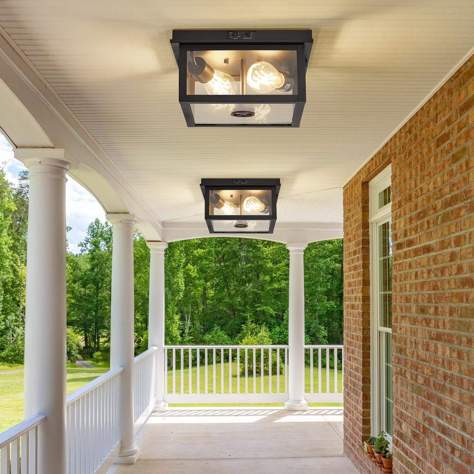 Traditional porch with black-framed outdoor ceiling lights, white columns, and a scenic green view beyond the railing.