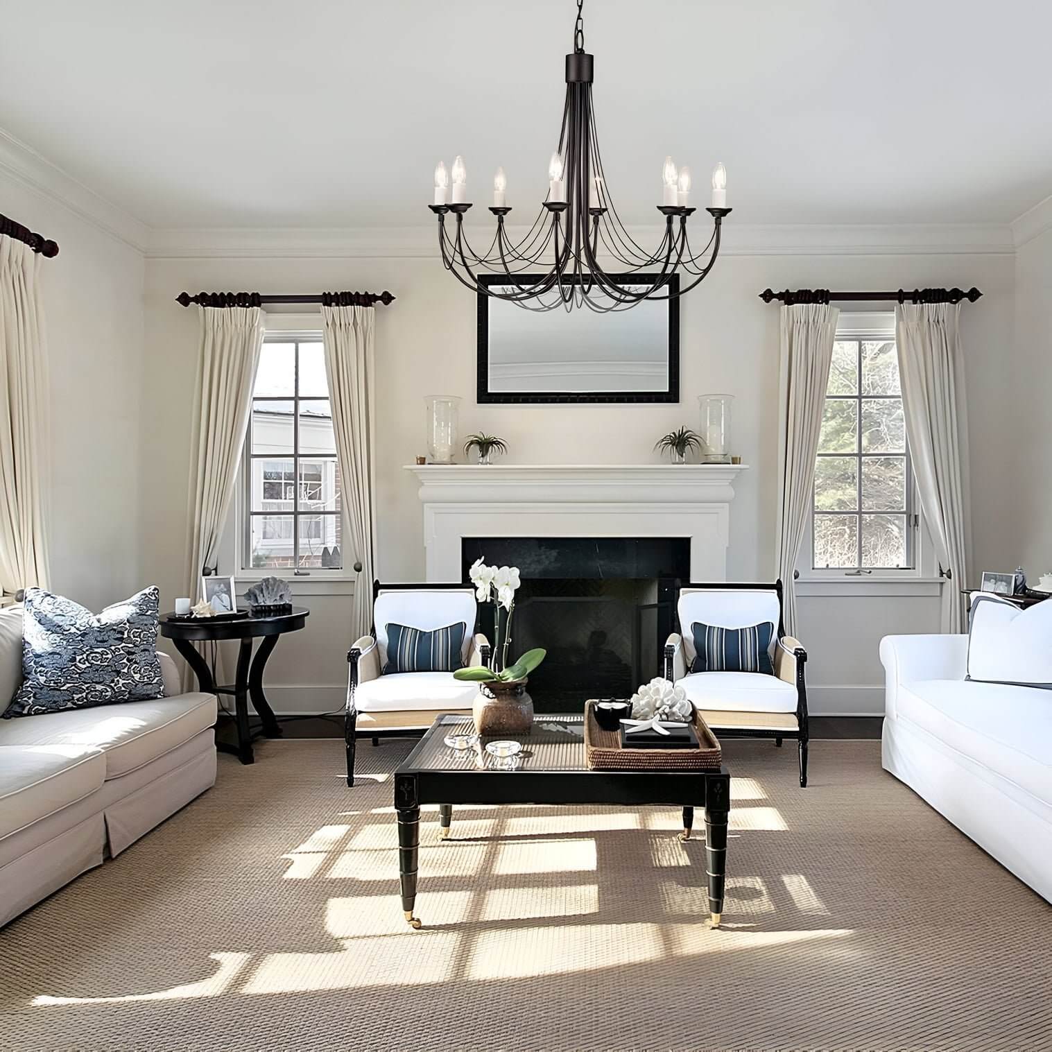 Black wrought iron chandelier with candle-style bulbs above a modern living room fireplace.