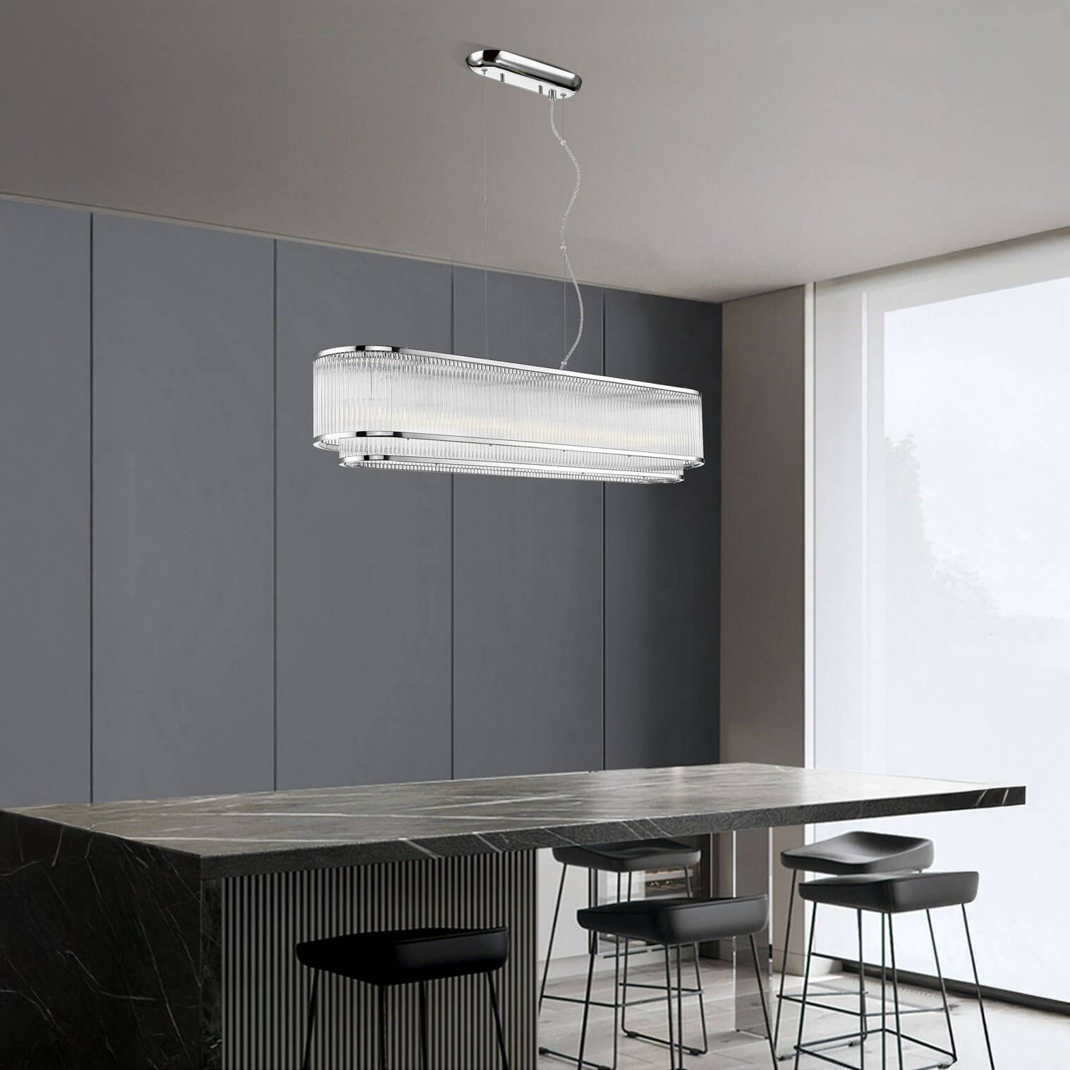 Rectangular crystal chandelier with chrome frame suspended above a black marble kitchen island.