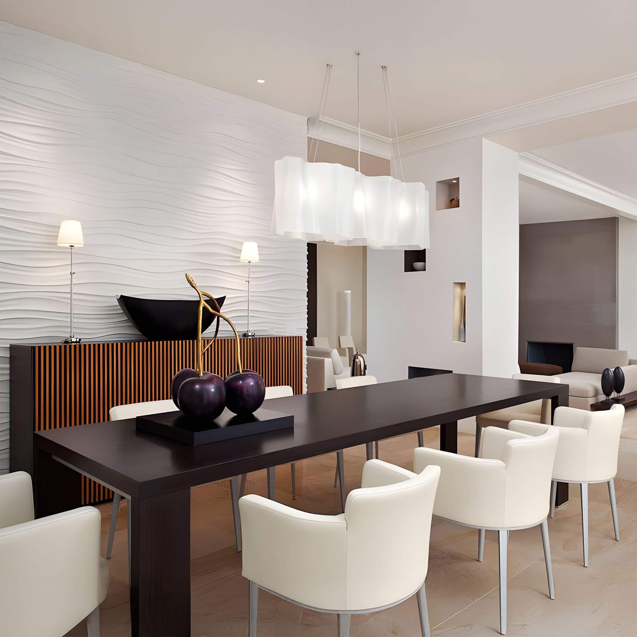 Layered white fabric pendant lights above a black dining table surrounded by cream chairs in a textured white interior.