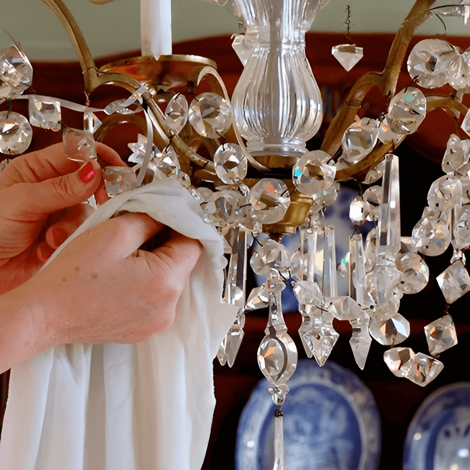 Carefully wiping crystal chandelier pieces with a soft cloth to clean and maintain shine.