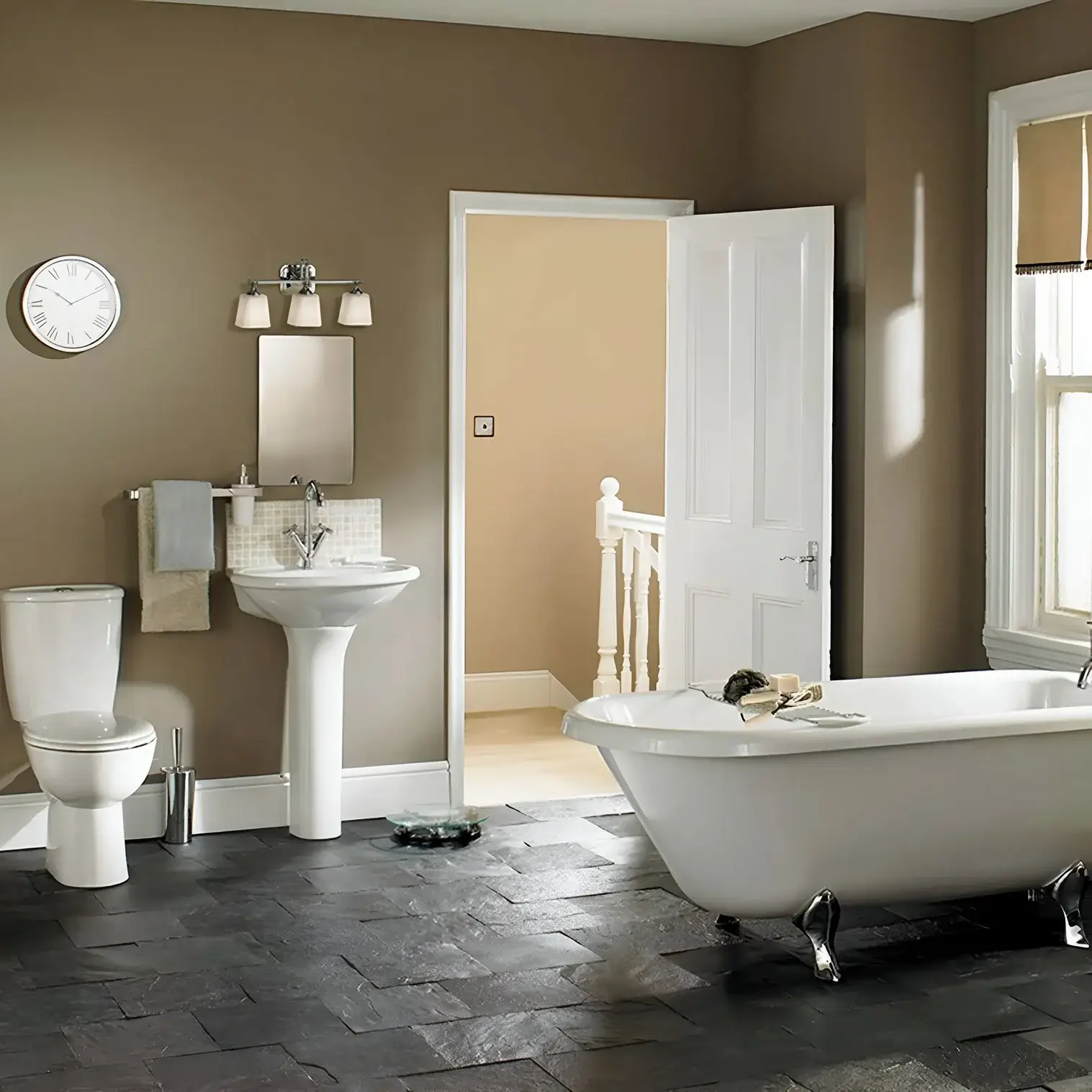 Traditional bathroom featuring a pedestal sink, clawfoot tub, and earthy tones with white trim for a warm, inviting feel.