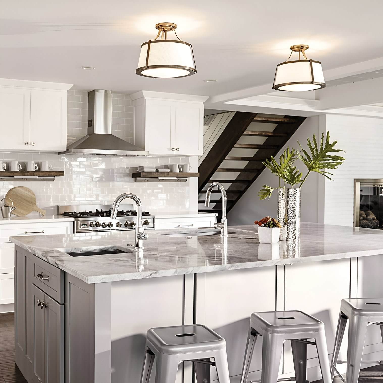 Pair of drum ceiling lights with metal trim and white shades in a kitchen.