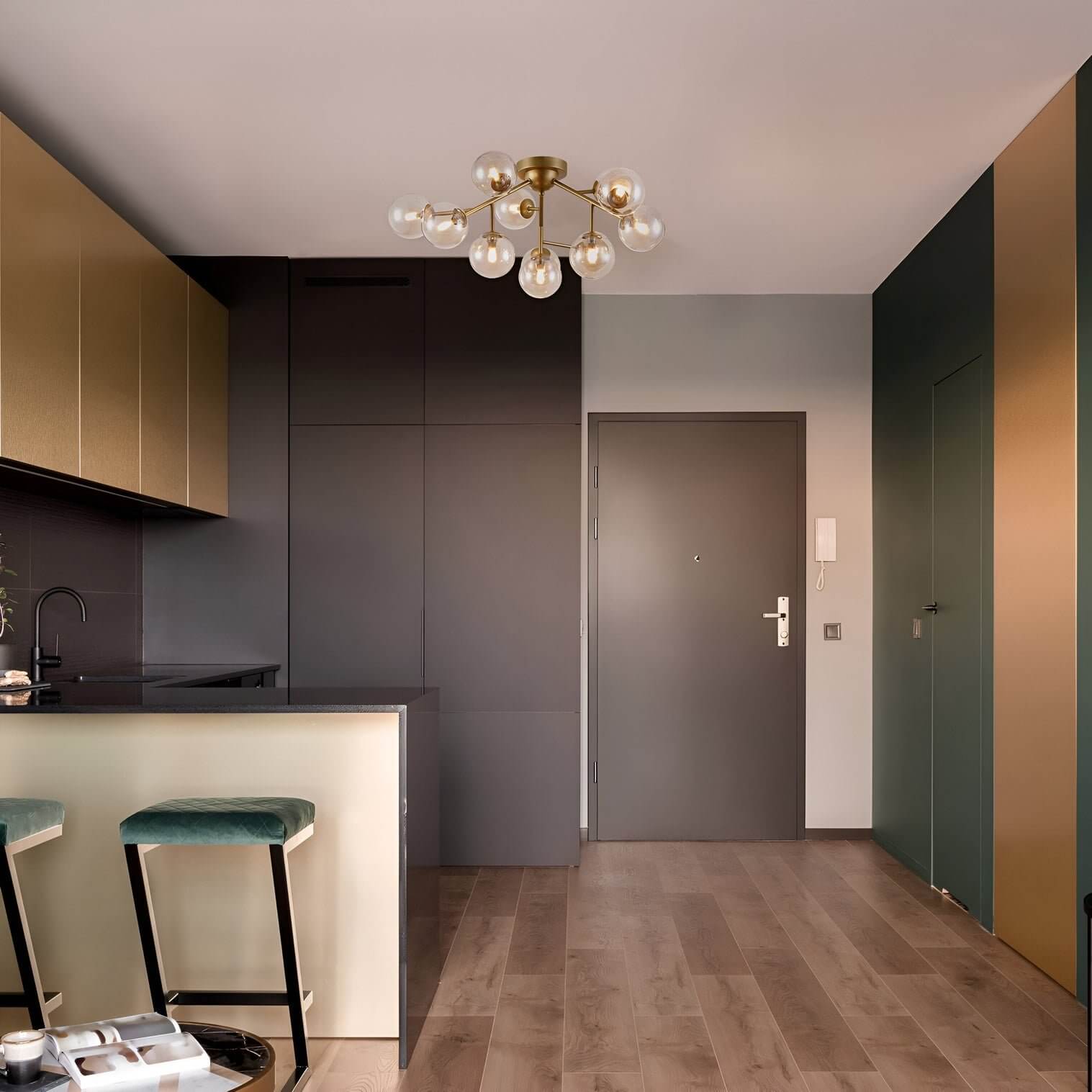 Brass mid-century chandelier with exposed globe bulbs in a sleek kitchen space.