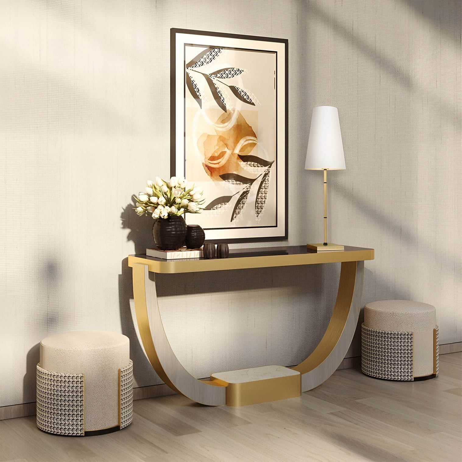 Curved console table with tall gold lamp, abstract art & textured stools in sunlit hallway