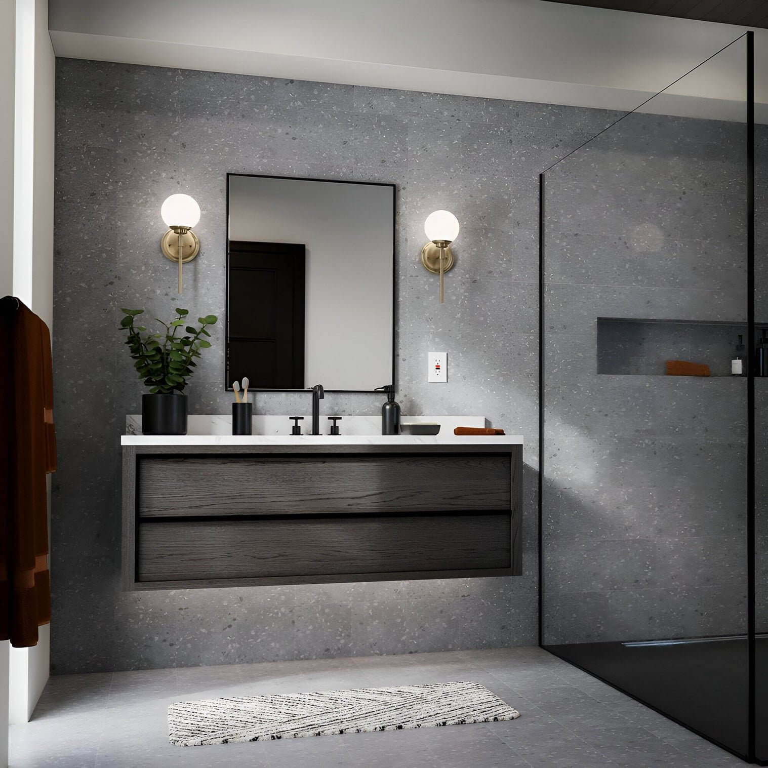 Minimalist bathroom with gray stone walls, black floating vanity, rectangular mirror, and globe wall sconces with brass bases.