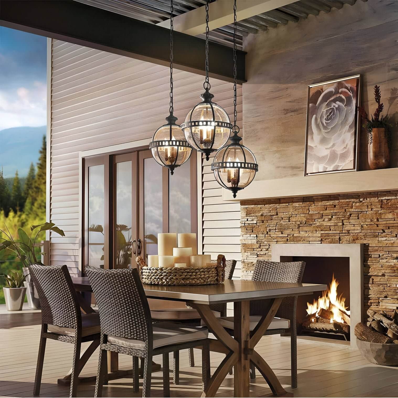 Rustic patio dining with stone fireplace and outdoor chandeliers, set under a vaulted metal roof with woven-back chairs.