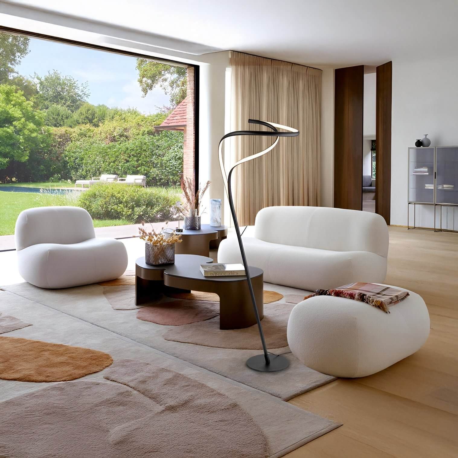 Sculptural black floor lamp with twin curved LED arms in a bright modern living room.